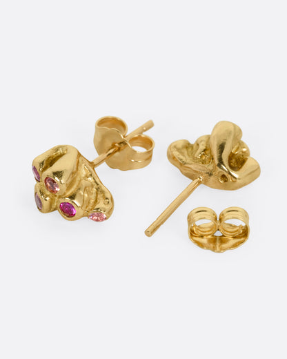 A pair of yellow gold stud earrings with clusters of orange and pink sapphires,. One earring is shown from the side, the other is shown open from the back.