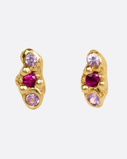 Kimberlin Brown Cloud stud earrings in 18k yellow gold, a molten gold cloud set with a red sapphire between two pink sapphires