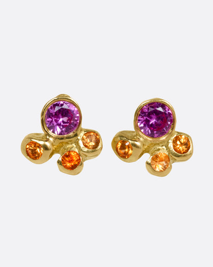 A pair of yellow gold stud earrings with pink and orange sapphire clusters, shown from the front.