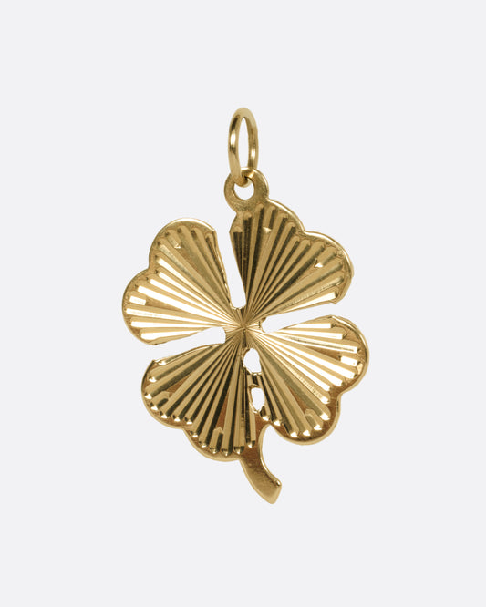 A yellow gold four leaf clover charm with a ridged texture, shown from the front.