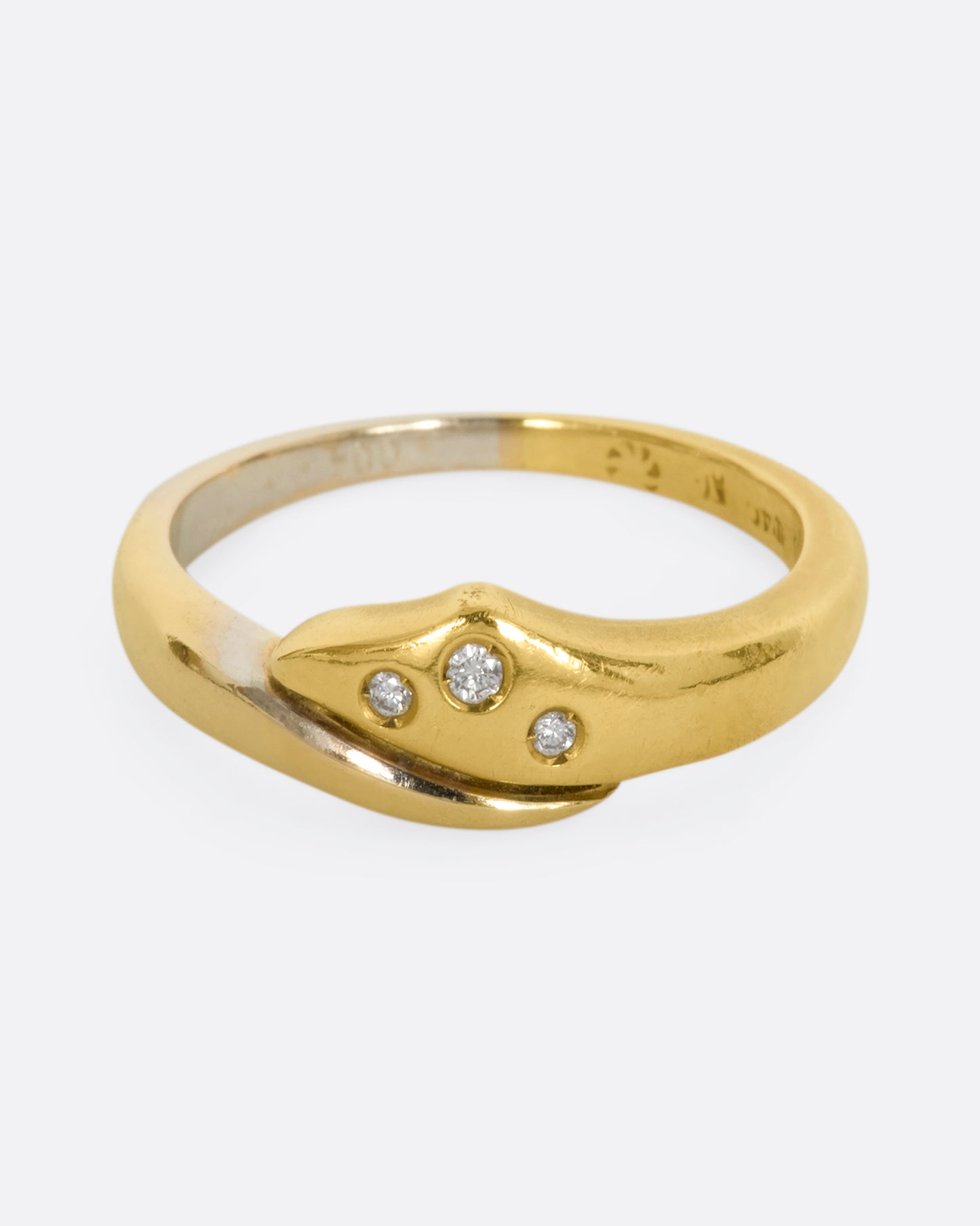 A yellow and white gold wrap ring with three diamonds. Shown from the front.