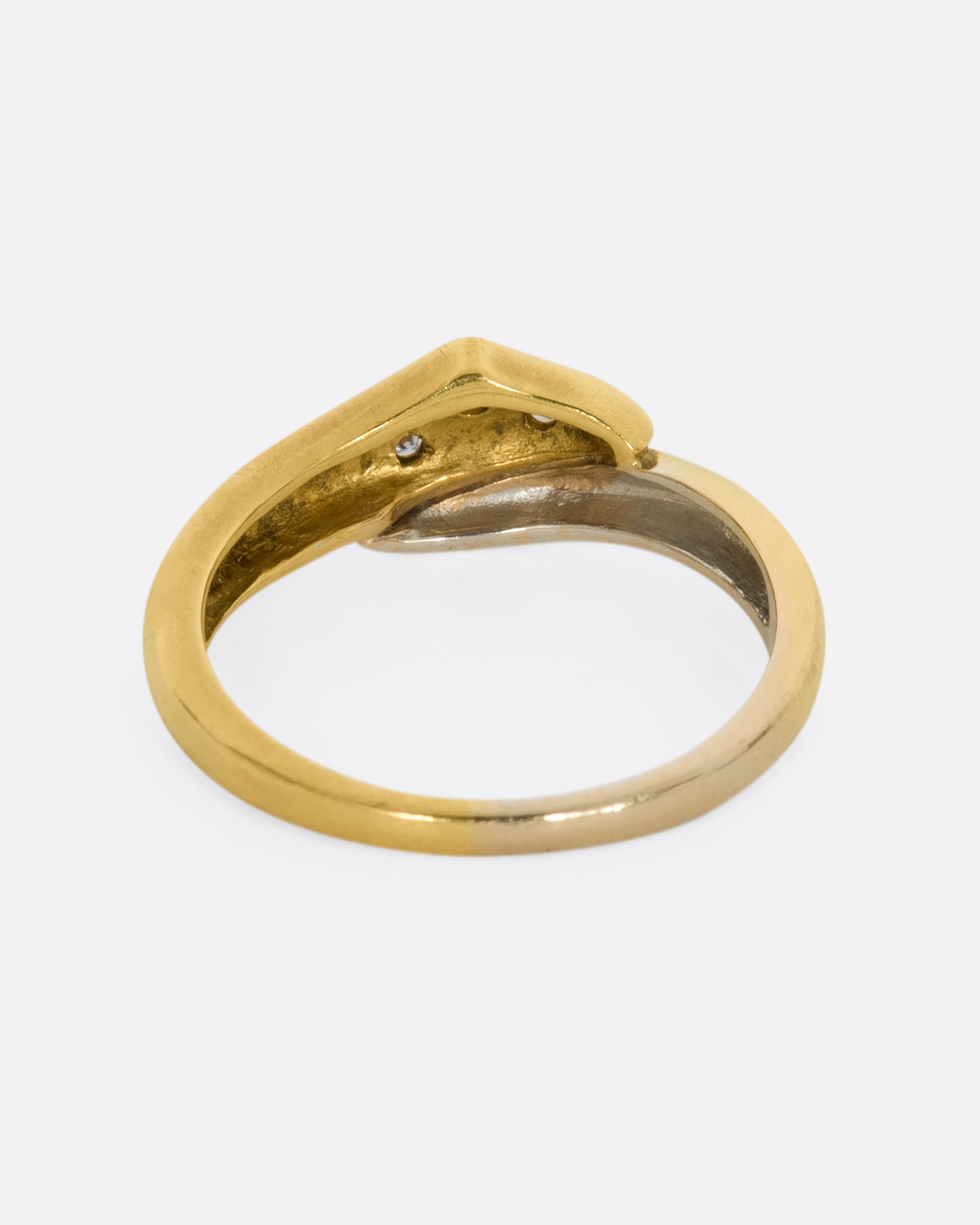 A yellow and white gold wrap ring with three diamonds. Shown from the back.