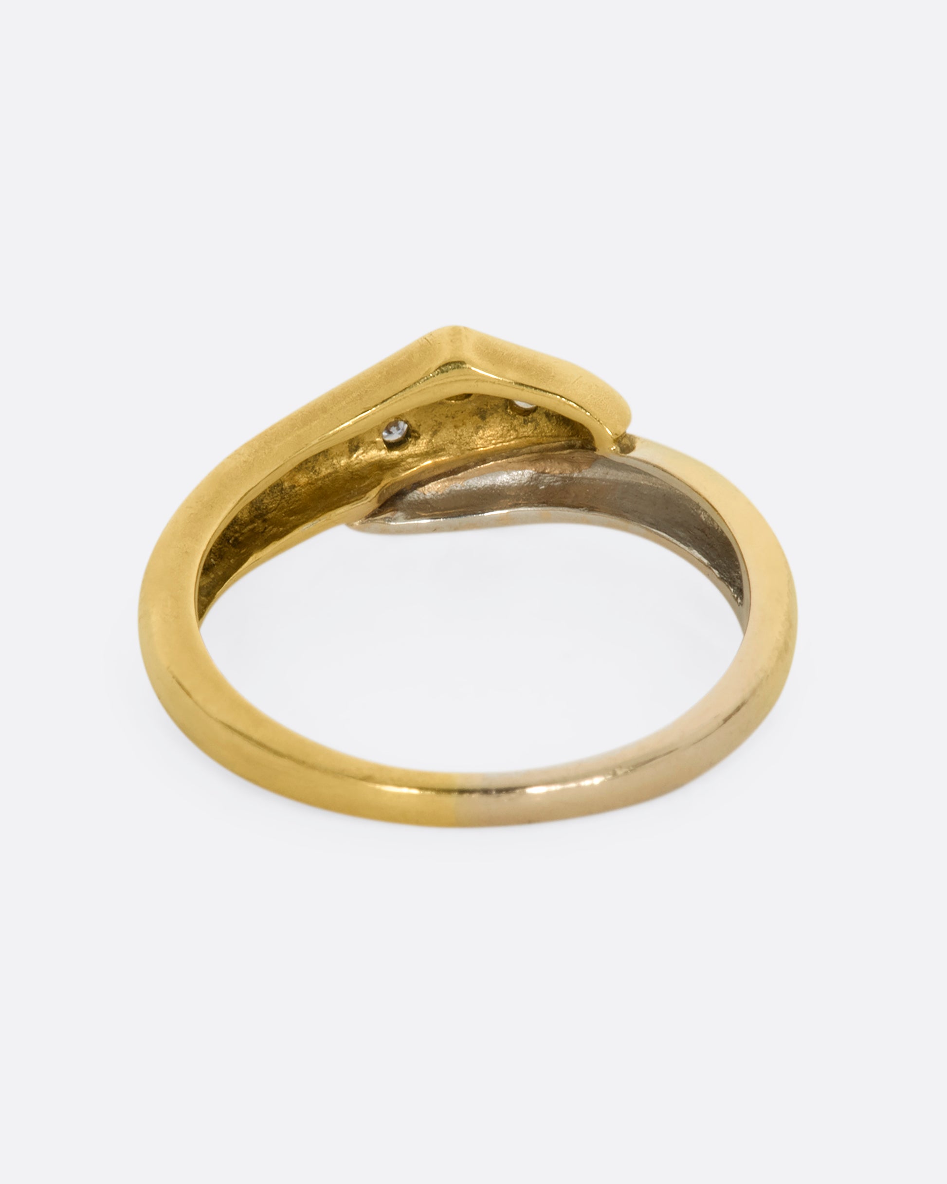 A yellow and white gold wrap ring with three diamonds. Shown from the back.