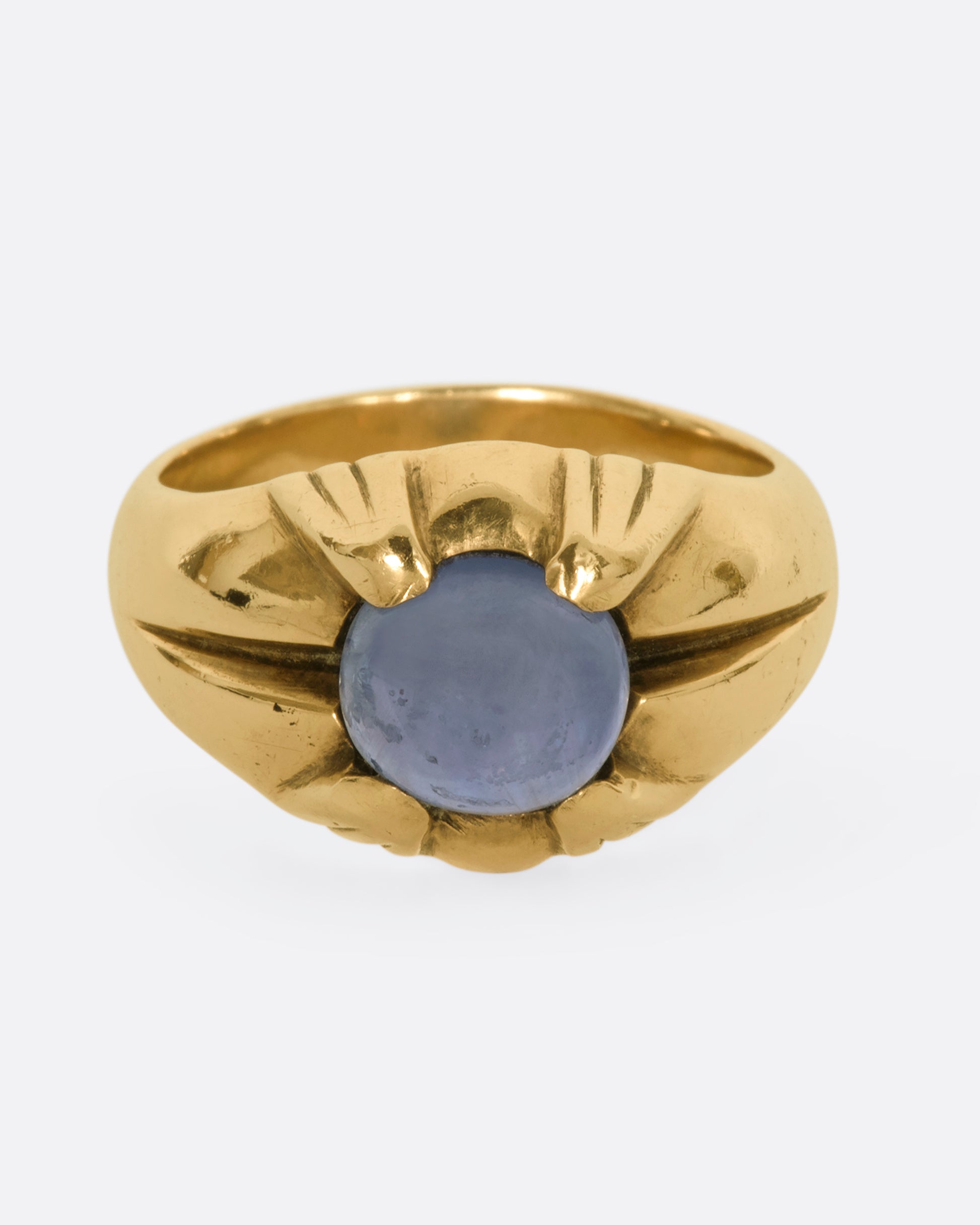 A yellow gold ring with a prong set star sapphire. View from the front.