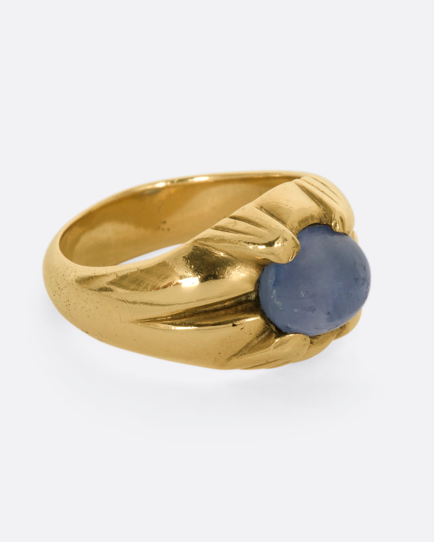 A yellow gold ring with a prong set star sapphire. View from the alternate side.