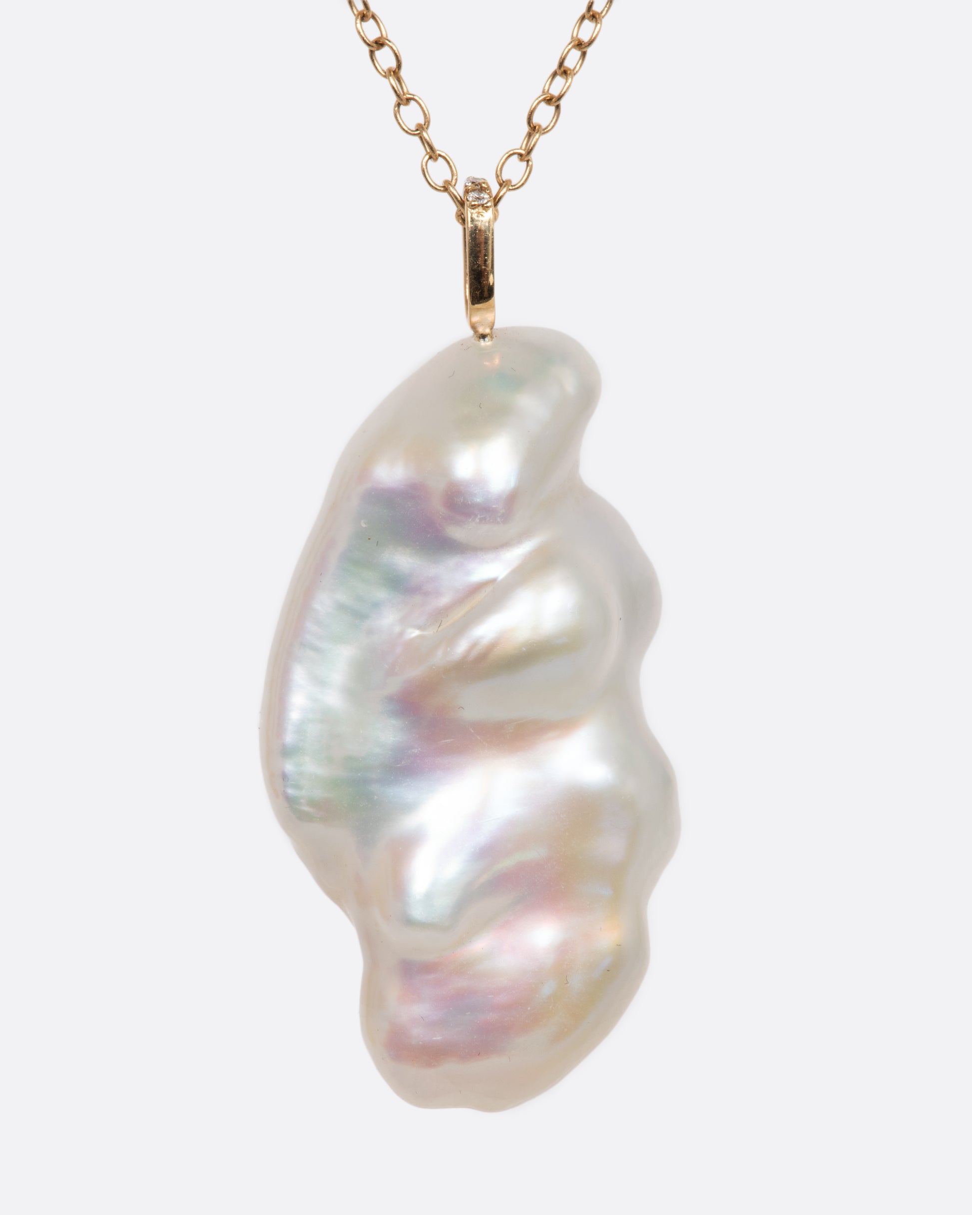 A yellow gold necklace with a hollowed out pearl pendant filled with amethysts and a pave diamond bale. Shown from the back.