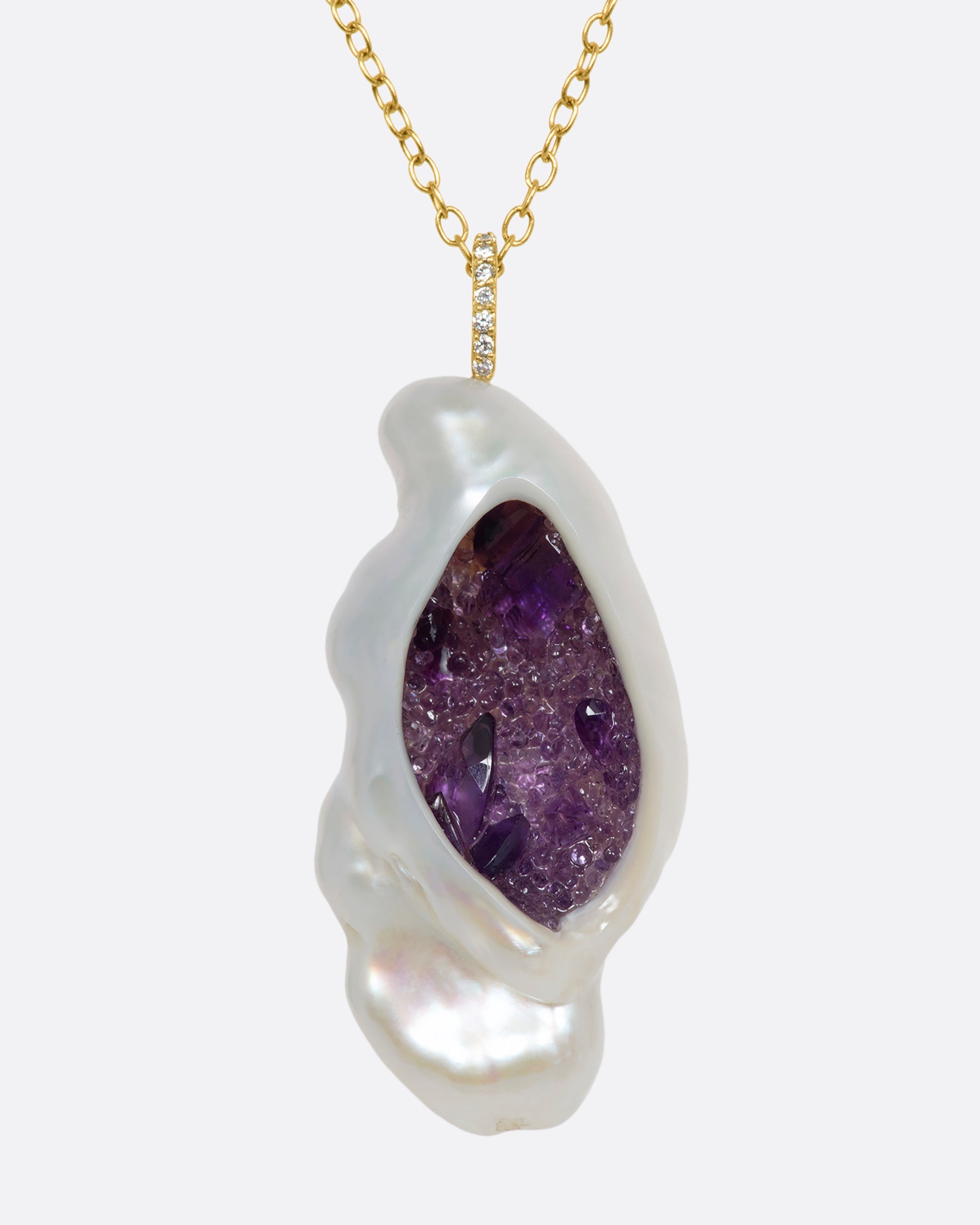 A yellow gold necklace with a hollowed out pearl pendant filled with amethysts and a pave diamond bale. Shown from the front.