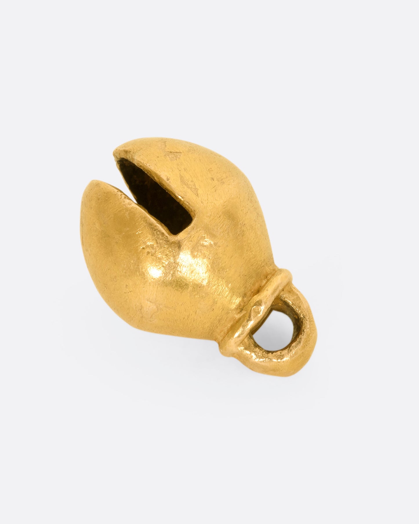 A yellow gold bell charm or pendant. View laying flat.