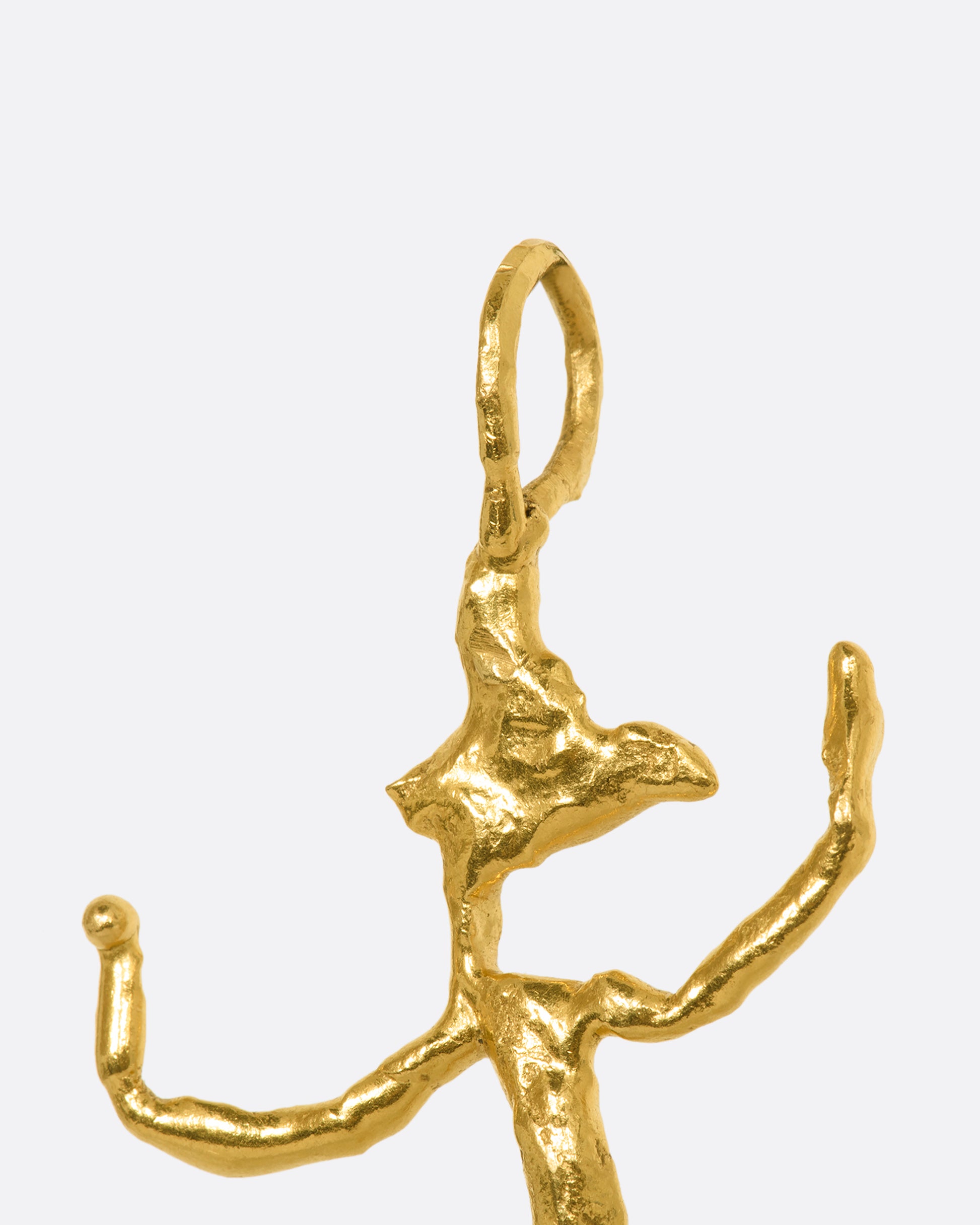 Yellow gold abstract creature pendant. Close up.