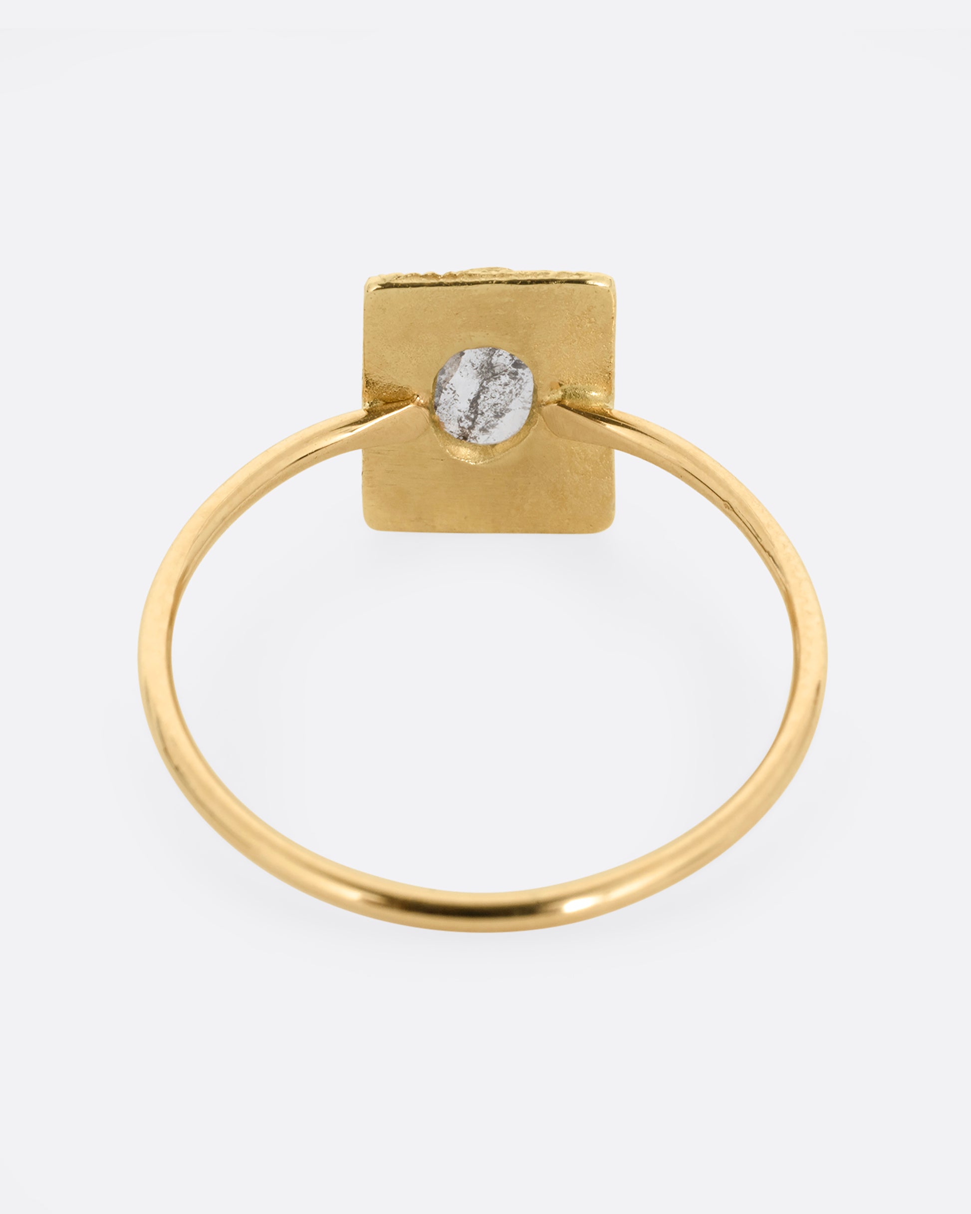 A yellow gold ring with an oval rose cut diamond in a rectangular setting. Shown from the back.
