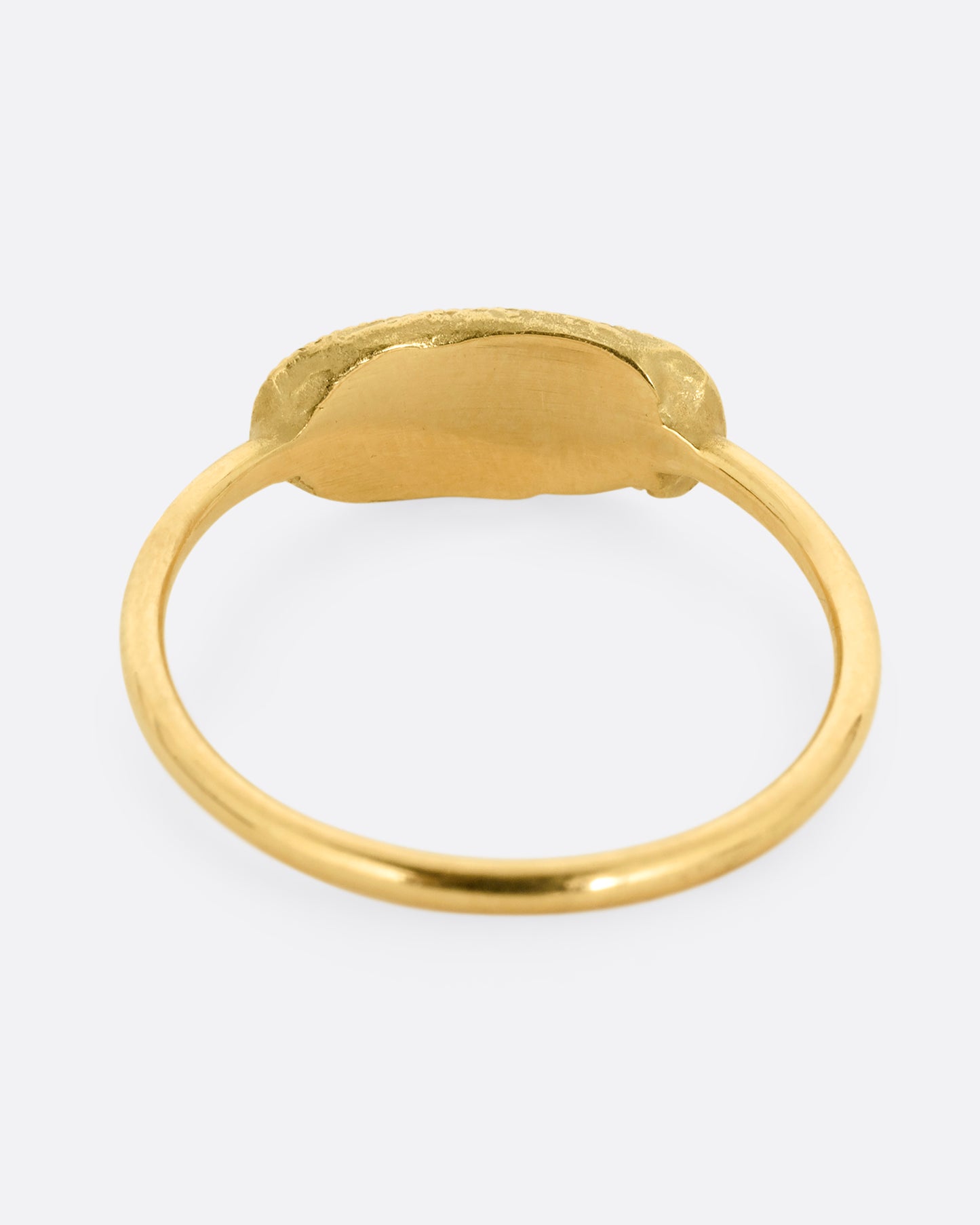 A yellow gold ring with a textural finish and five diamonds. Shown from the back.