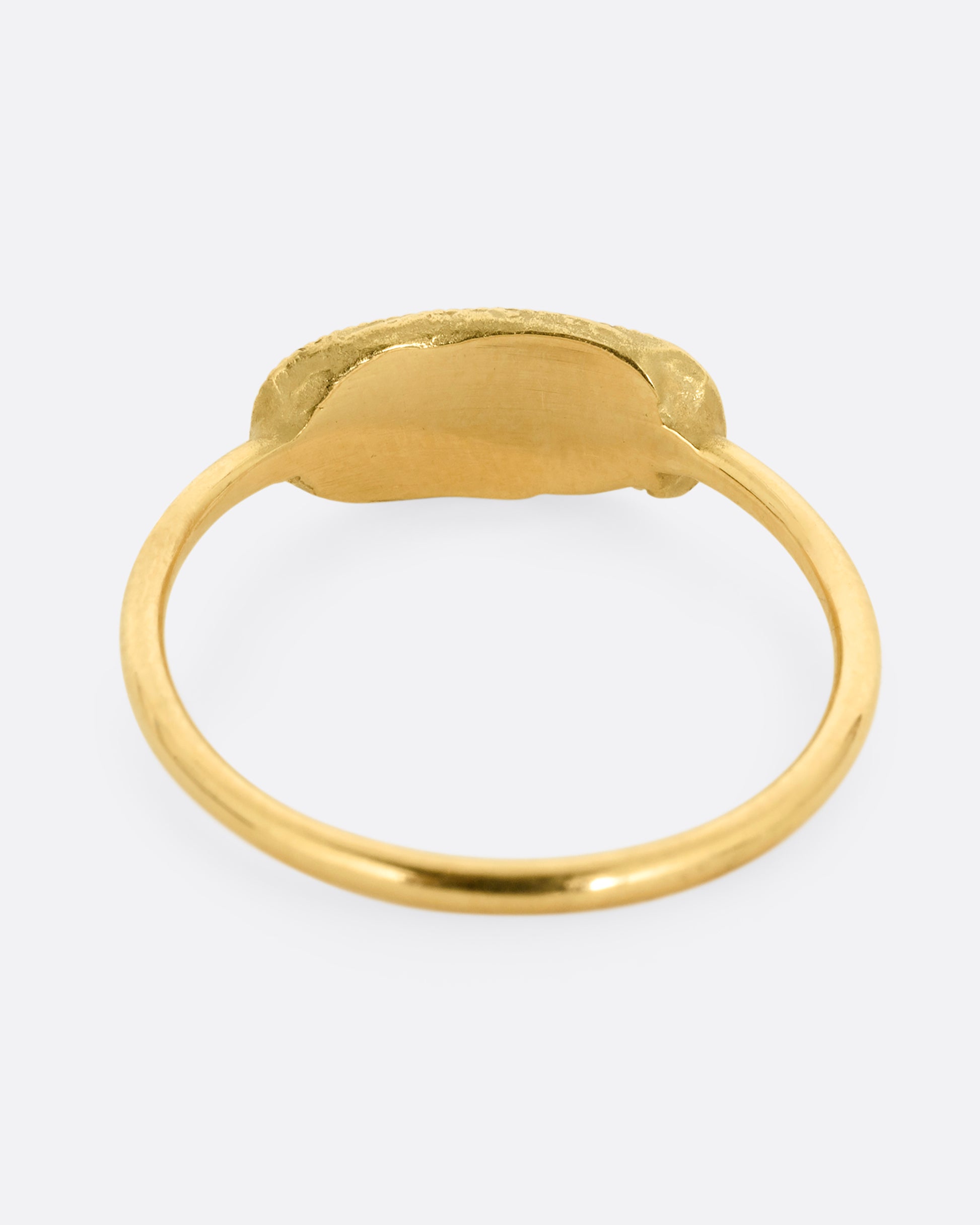 A yellow gold ring with a textural finish and five diamonds. Shown from the back.