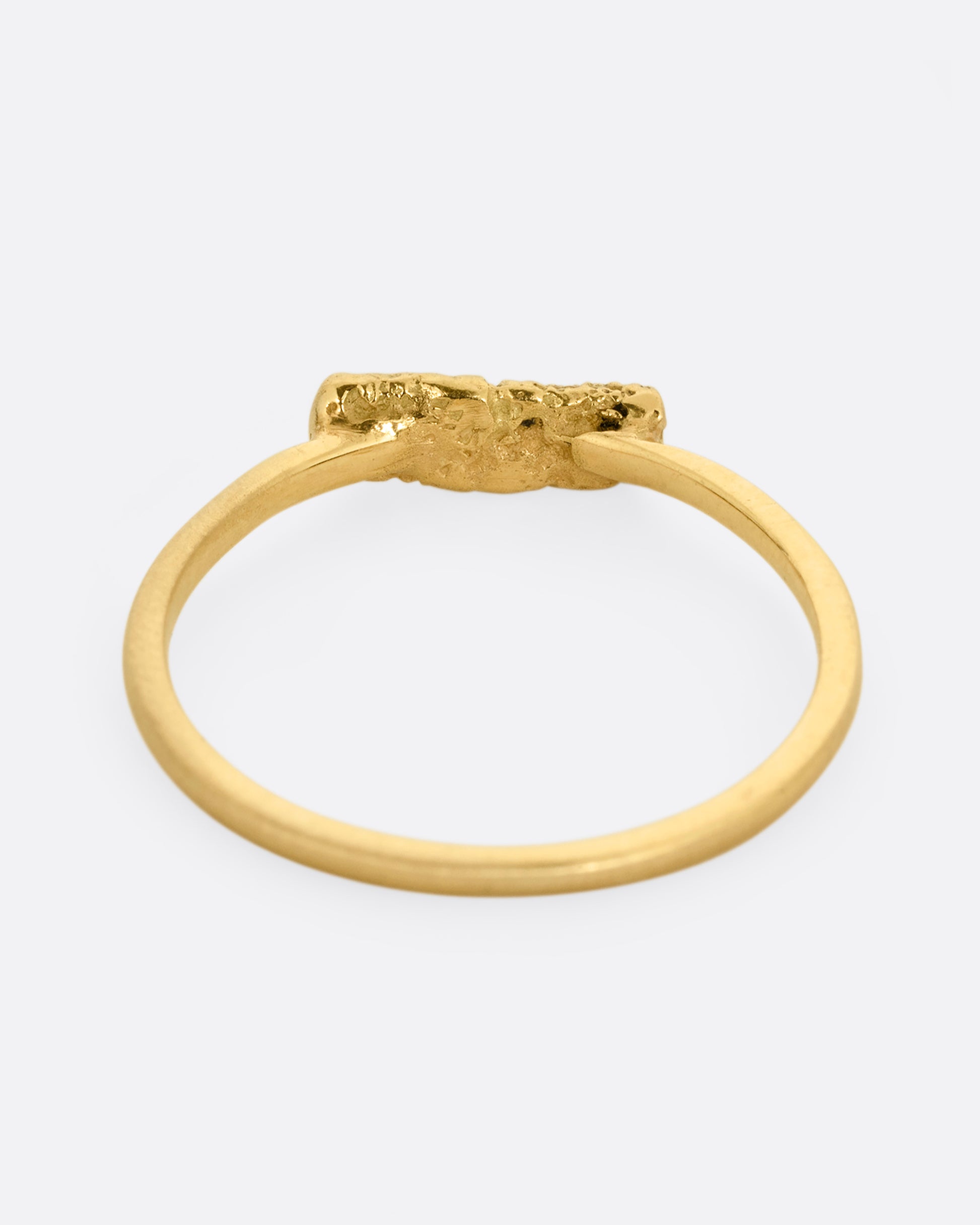A yellow gold ring with five black diamonds set in a textured rectangular face. Shown from the back.