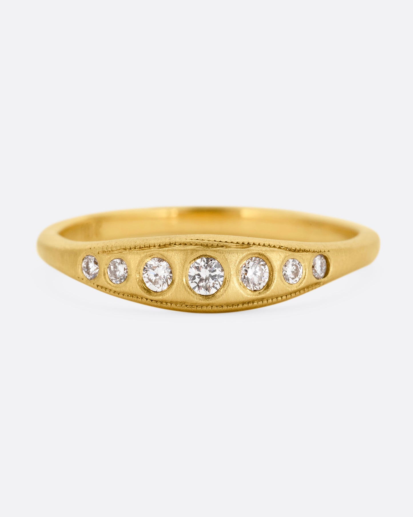 A yellow gold ring with seven diamonds. Shown from the front.