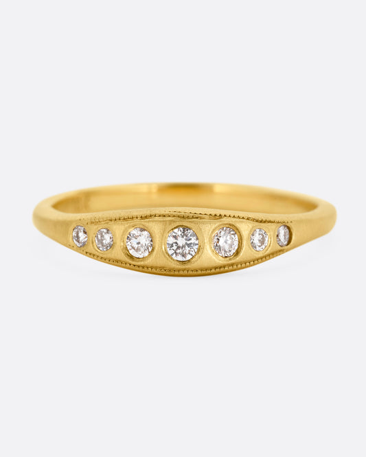 A yellow gold ring with seven diamonds. Shown from the front.