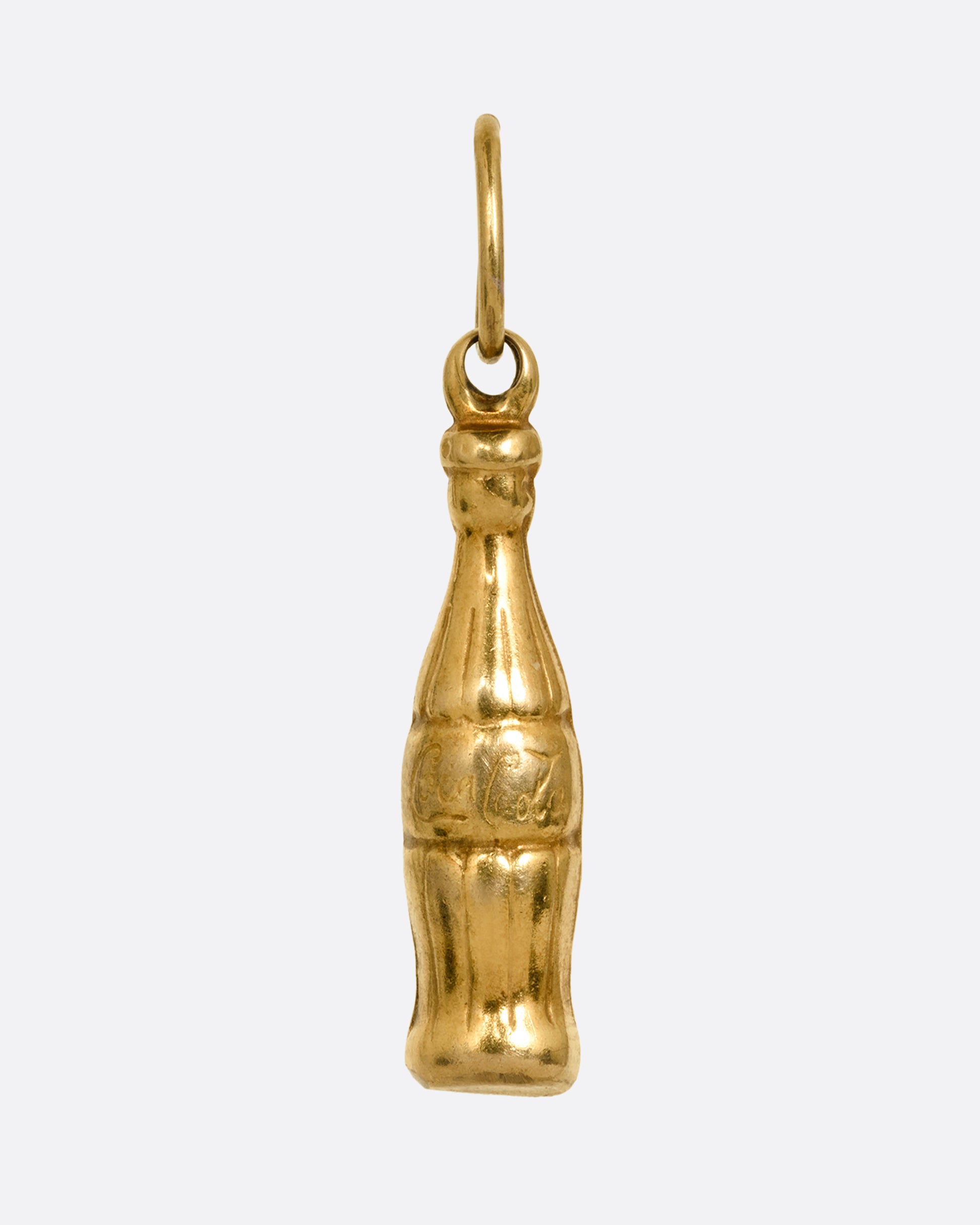 A yellow gold Coca-Cola bottle charm shown from the front.