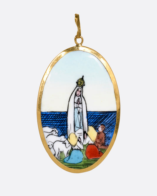 A yellow gold pendant with a hand painted image of the Virgin Mary sits at the center and "Na sa do Rosario da Patima" on its reverse. Shown from the front.