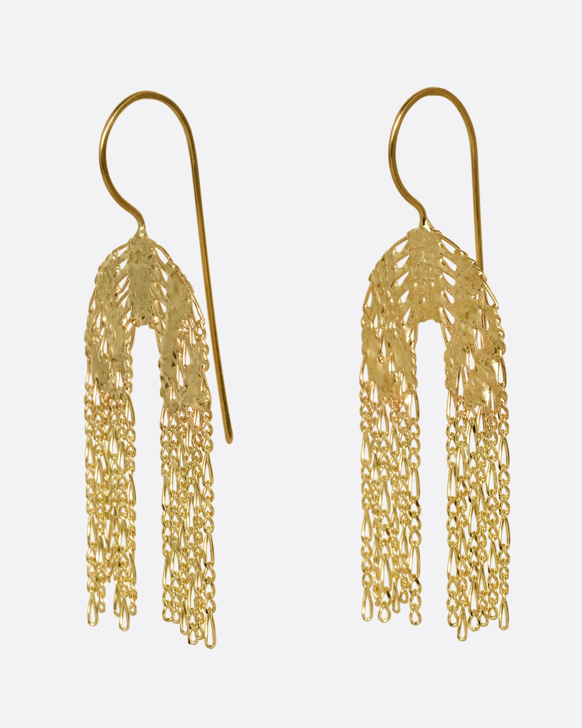 A pair of yellow gold dangle earrings with soldered rainbow shaped tops and Figaro chain fringe bottoms. Shown from the side.