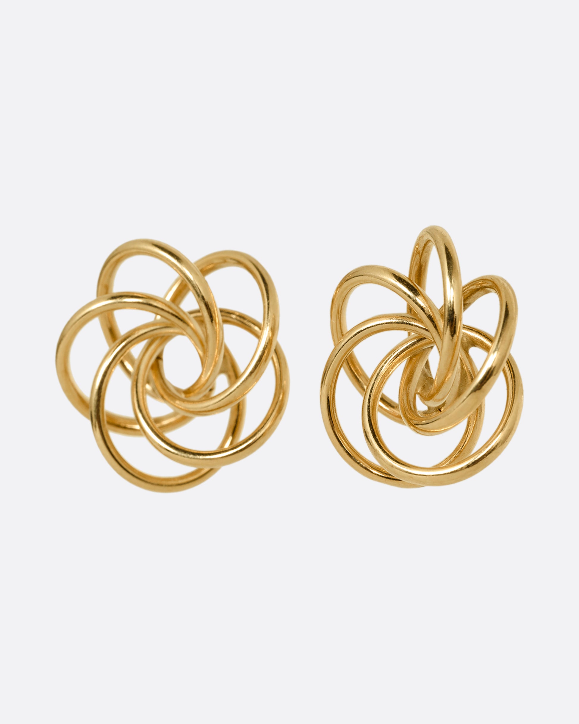 A pair of yellow gold earrings with knotted circles. Shown from the front.