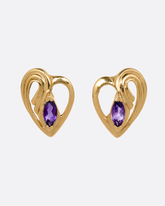 A pair of yellow gold heart shaped stud earrings with marquise amethysts at the center. Shown from the front.