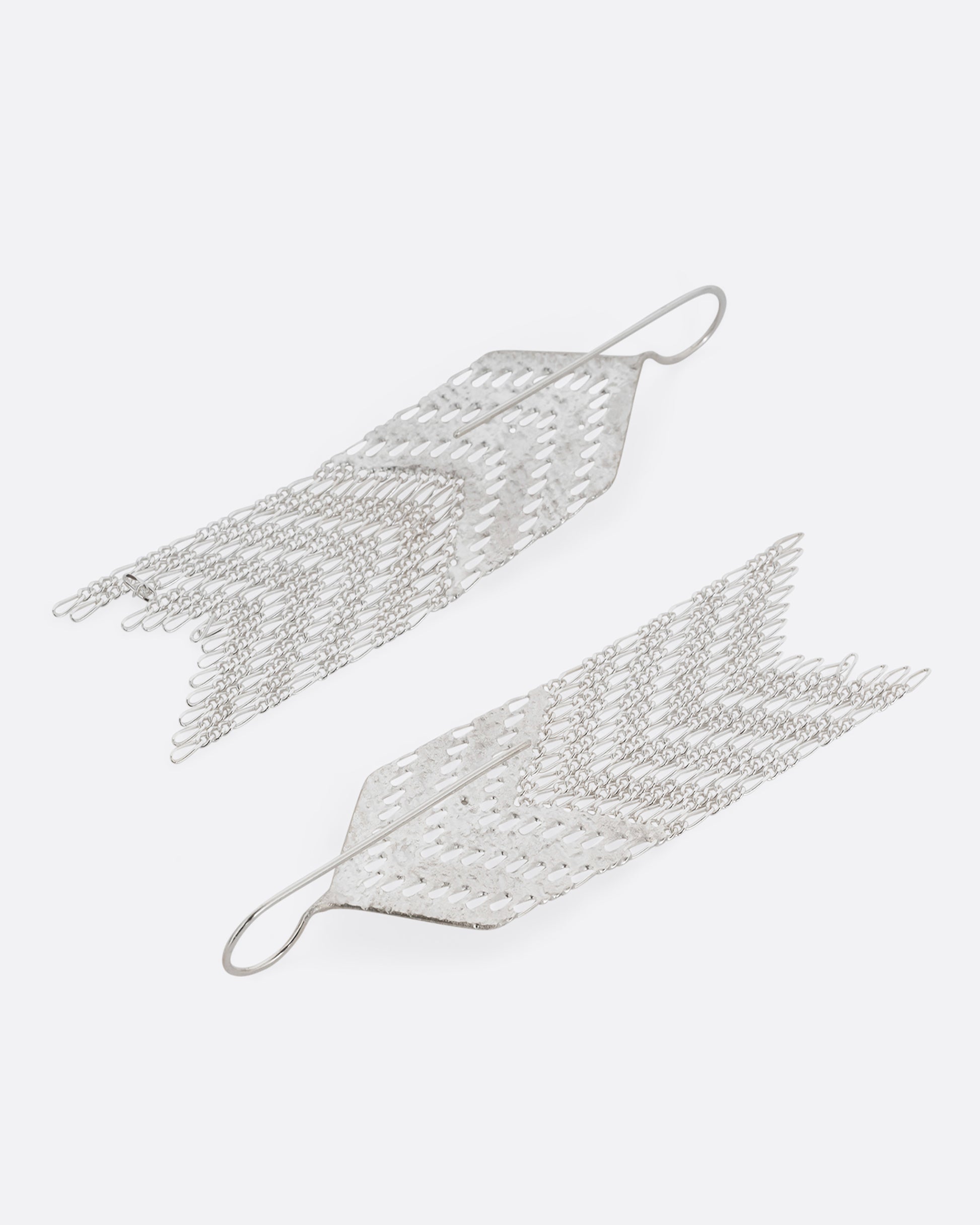 A pair of arrow shaped silver dangle earrings with Figaro chain fringe. Shown from the back.
