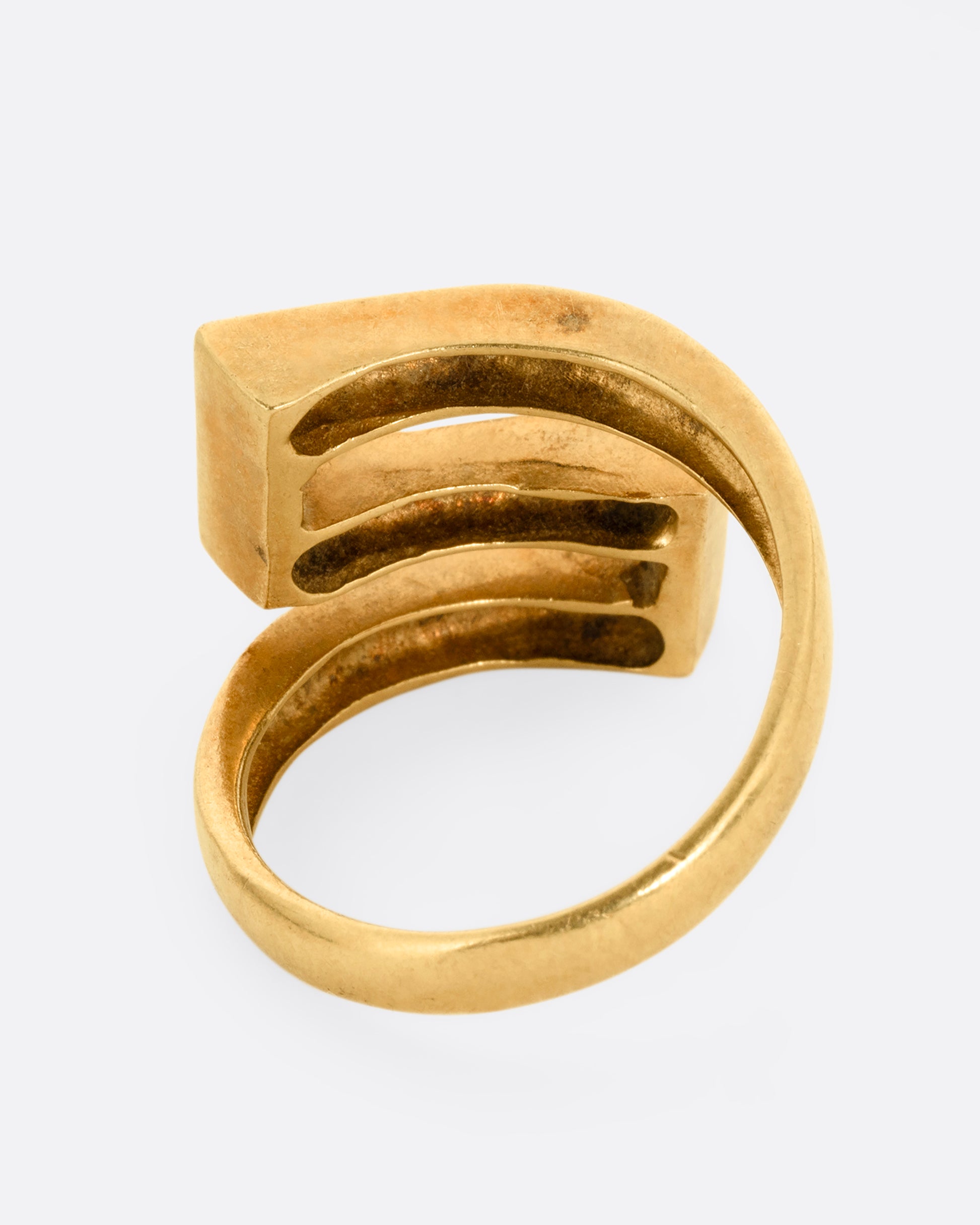 A yellow gold Greek Key ring with a zigzag pattern in green enamel, shown from the back.