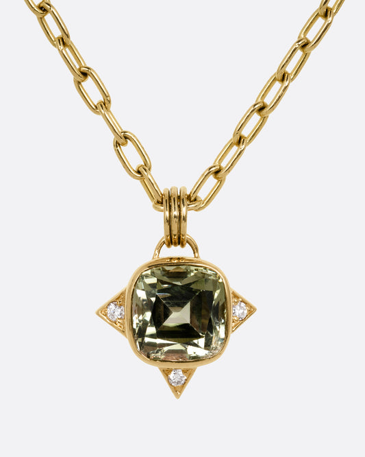 A yellow gold cable chain necklace with a green tourmaline and white diamond accents. Shown from the front.