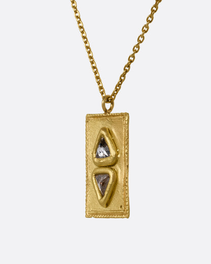 A cable chain necklace with two triangle shaped salt and pepper diamonds in a rectangle pendant. Shown from the side.