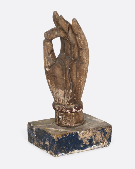 A wooden hand sculpture with the index and thumb touching. Shown from the side.