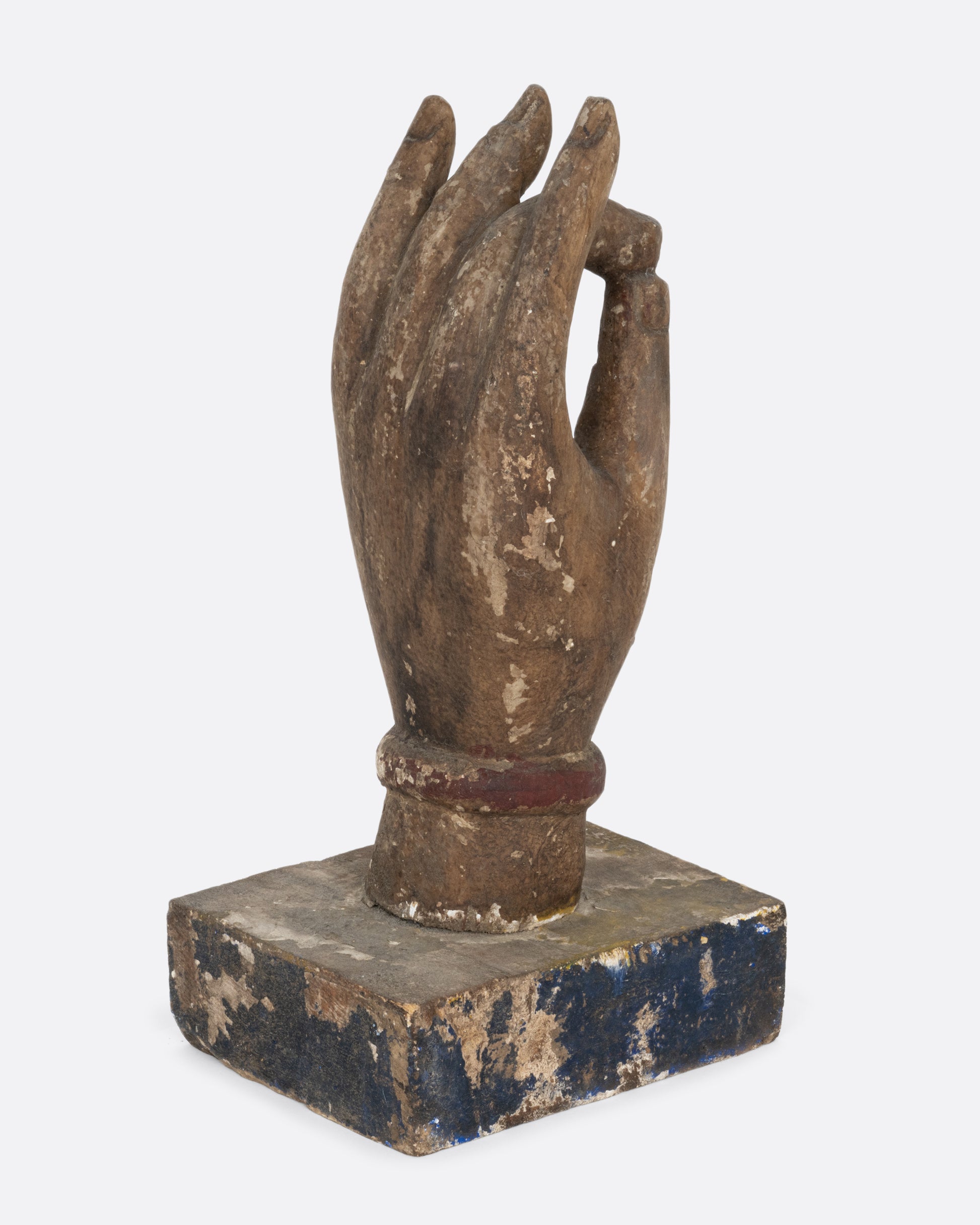 A wooden hand sculpture with the index and thumb touching. Shown from the back.