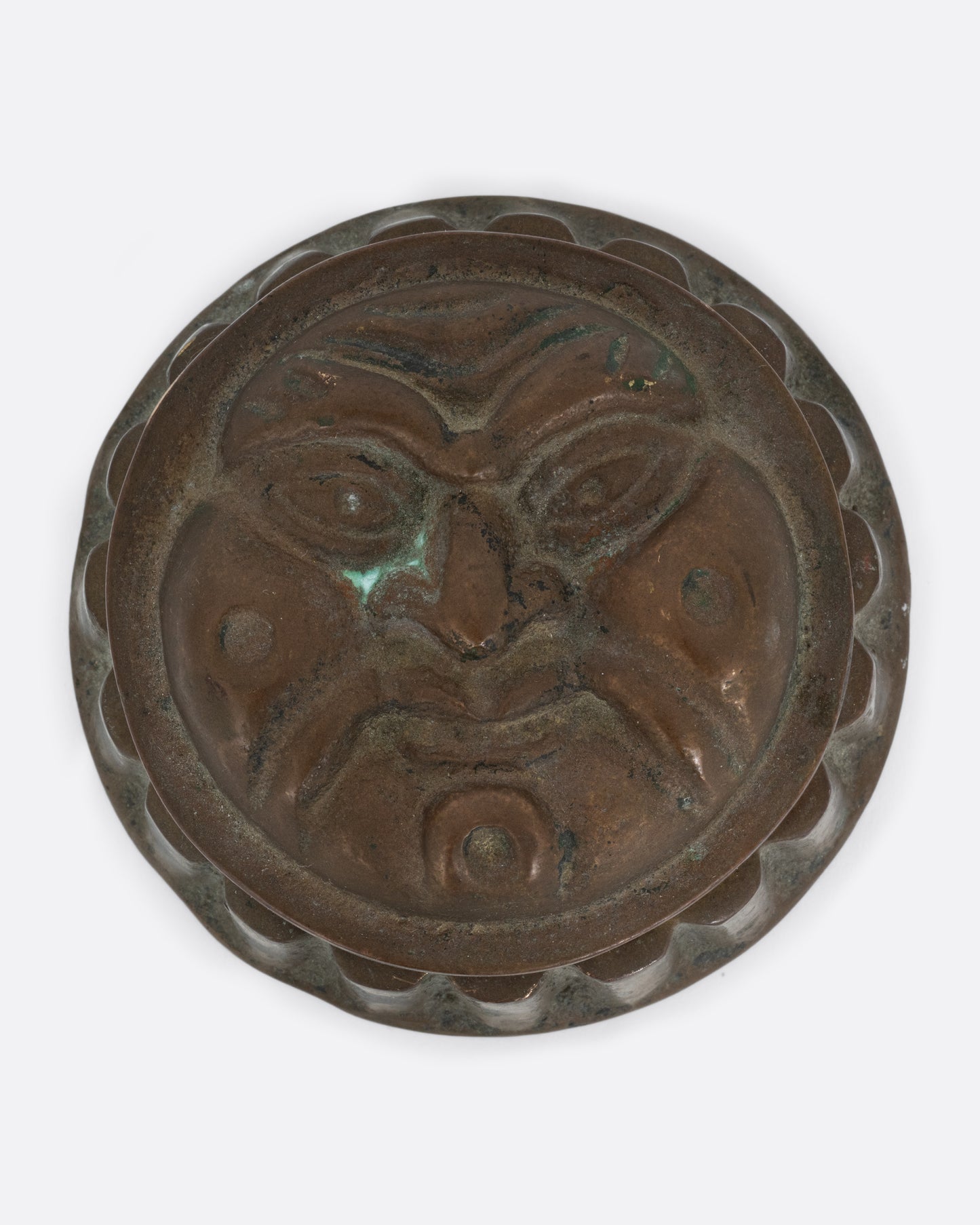 A round box with a face on the lid and ridged sides. Shown from the top.