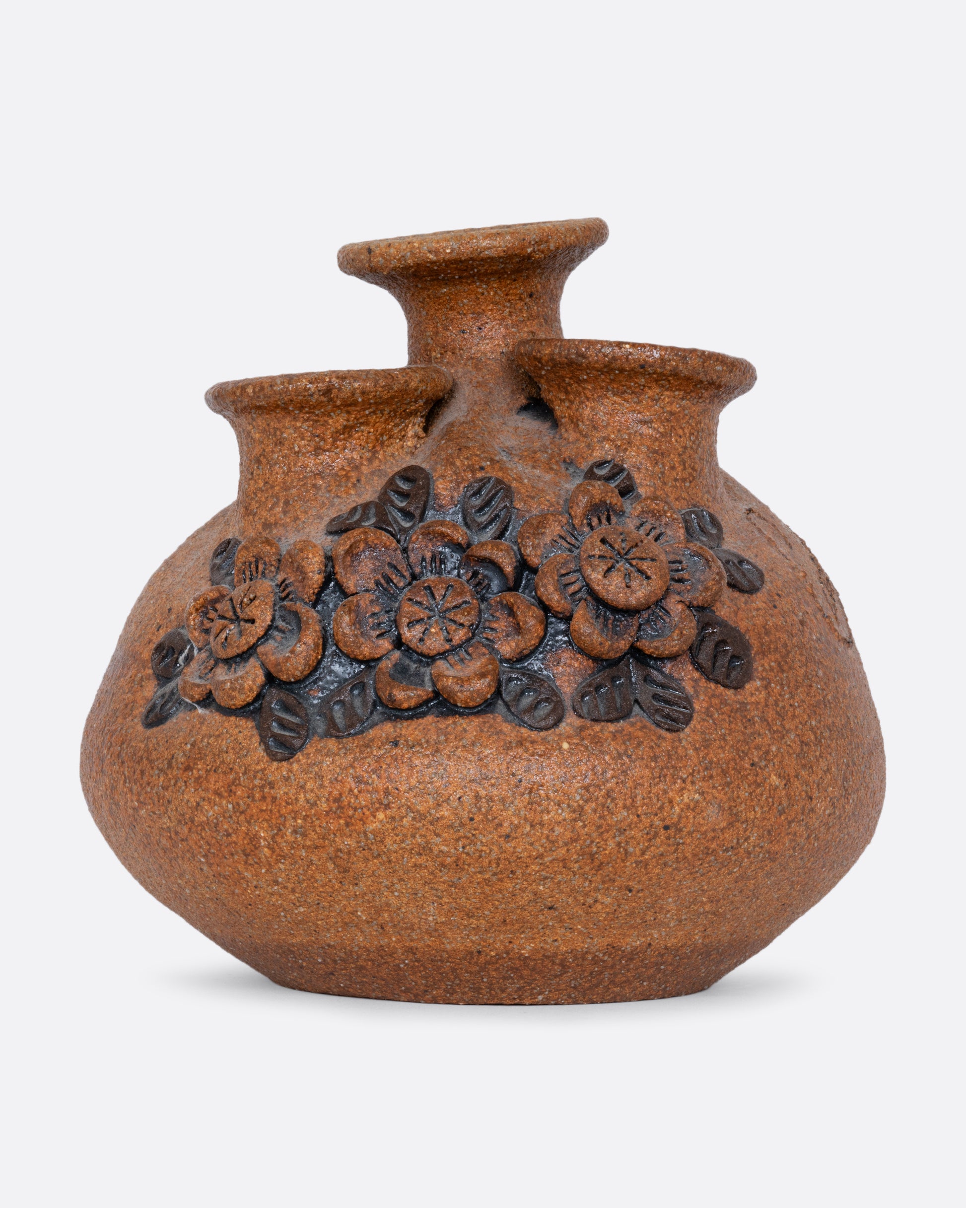 A sand art pottery vase with three openings for flowers and a floral pattern along the front. Shown from the front.
