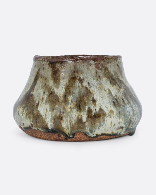 This ceramic planter with a green marbled glaze and drainage hole. Shown from the front.