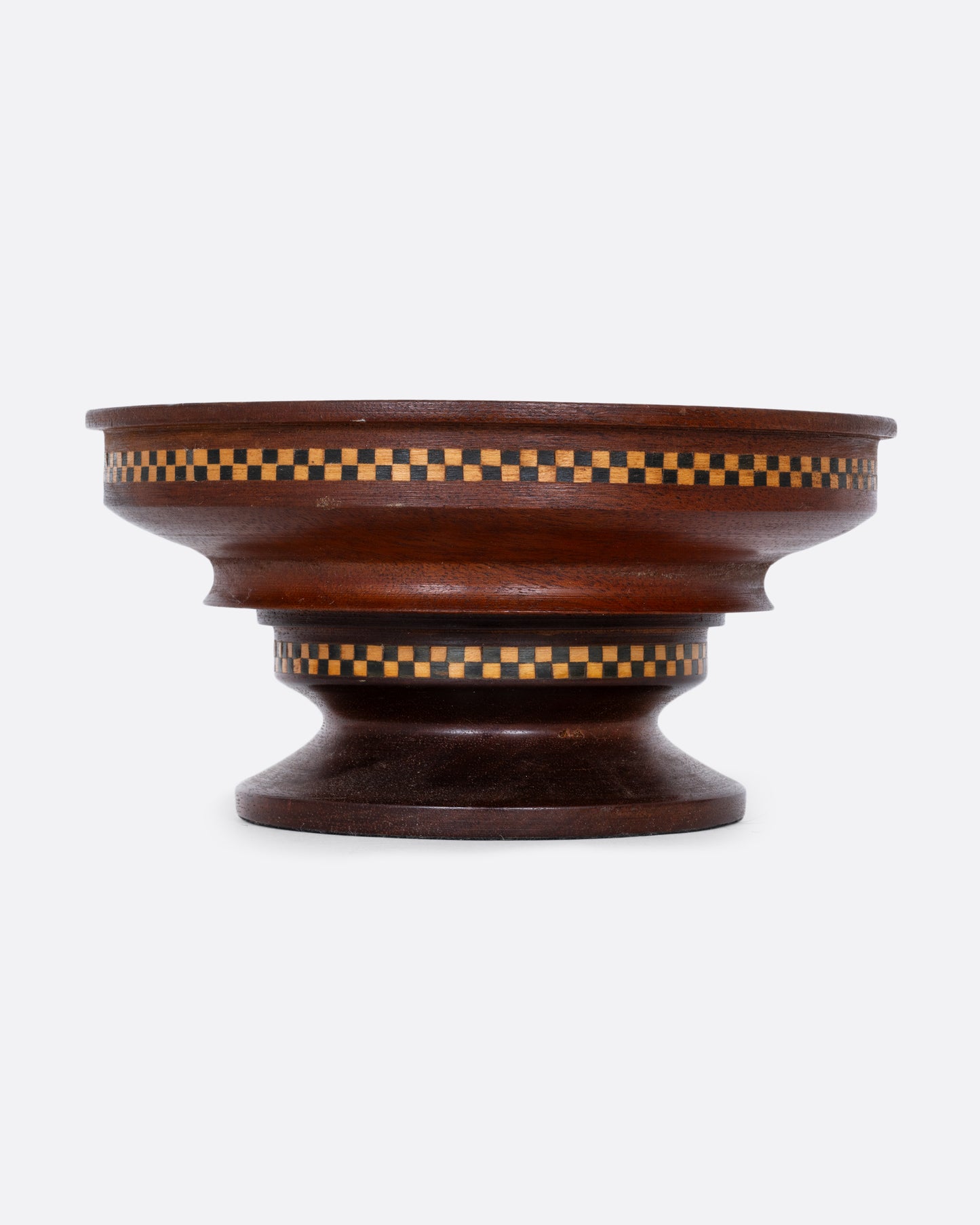 A wooden hand turned bowl with a checkerboard inlay and felted bottom. Shown from the front.