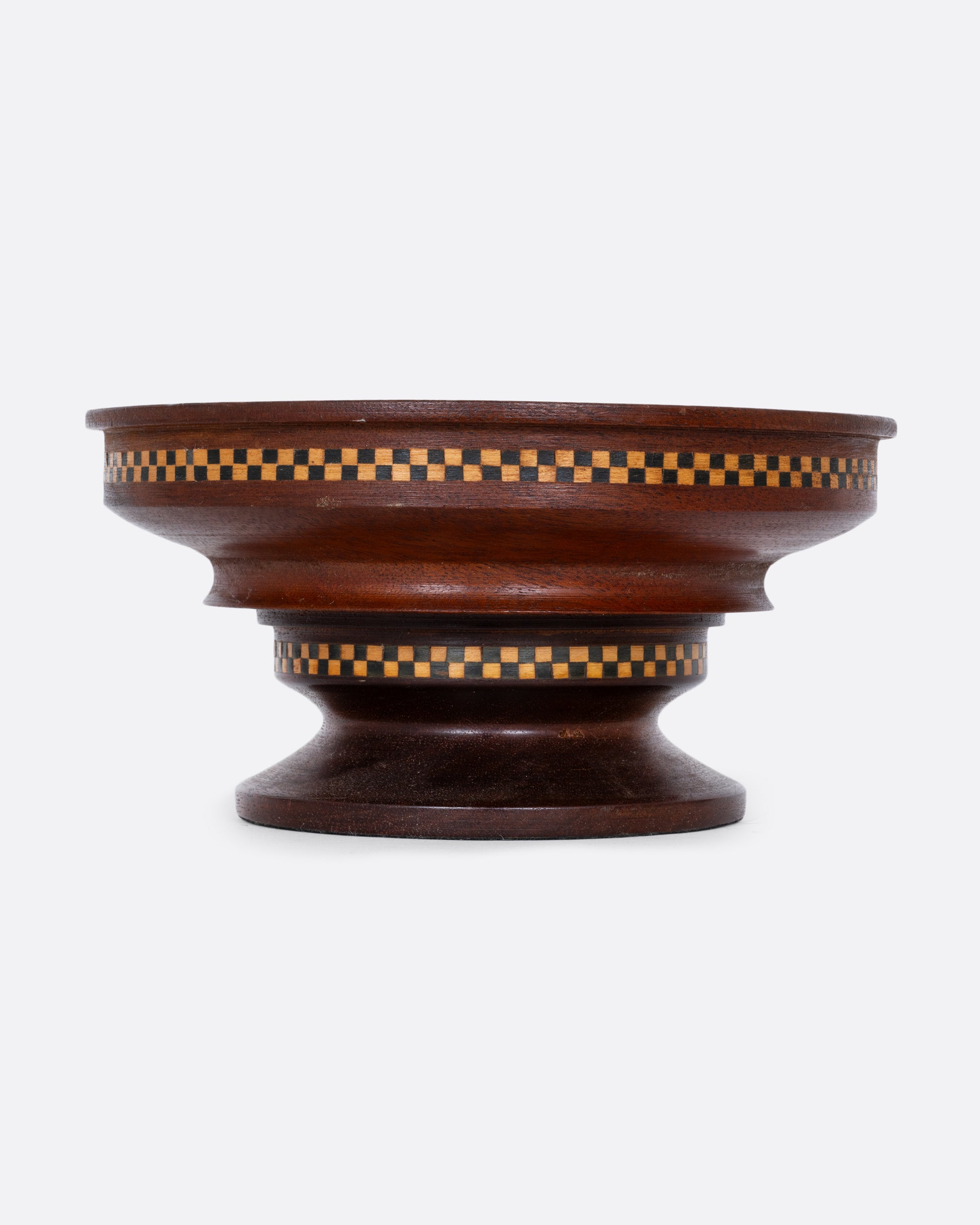 A wooden hand turned bowl with a checkerboard inlay and felted bottom. Shown from the front.