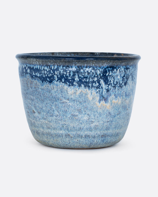 A pot with an azure glaze and drainage hole. Shown from the front.