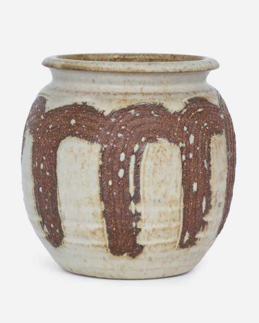 A tan pot wreathed in russet- brown brush strokes with a drainage hole at its base. Shown from the front.