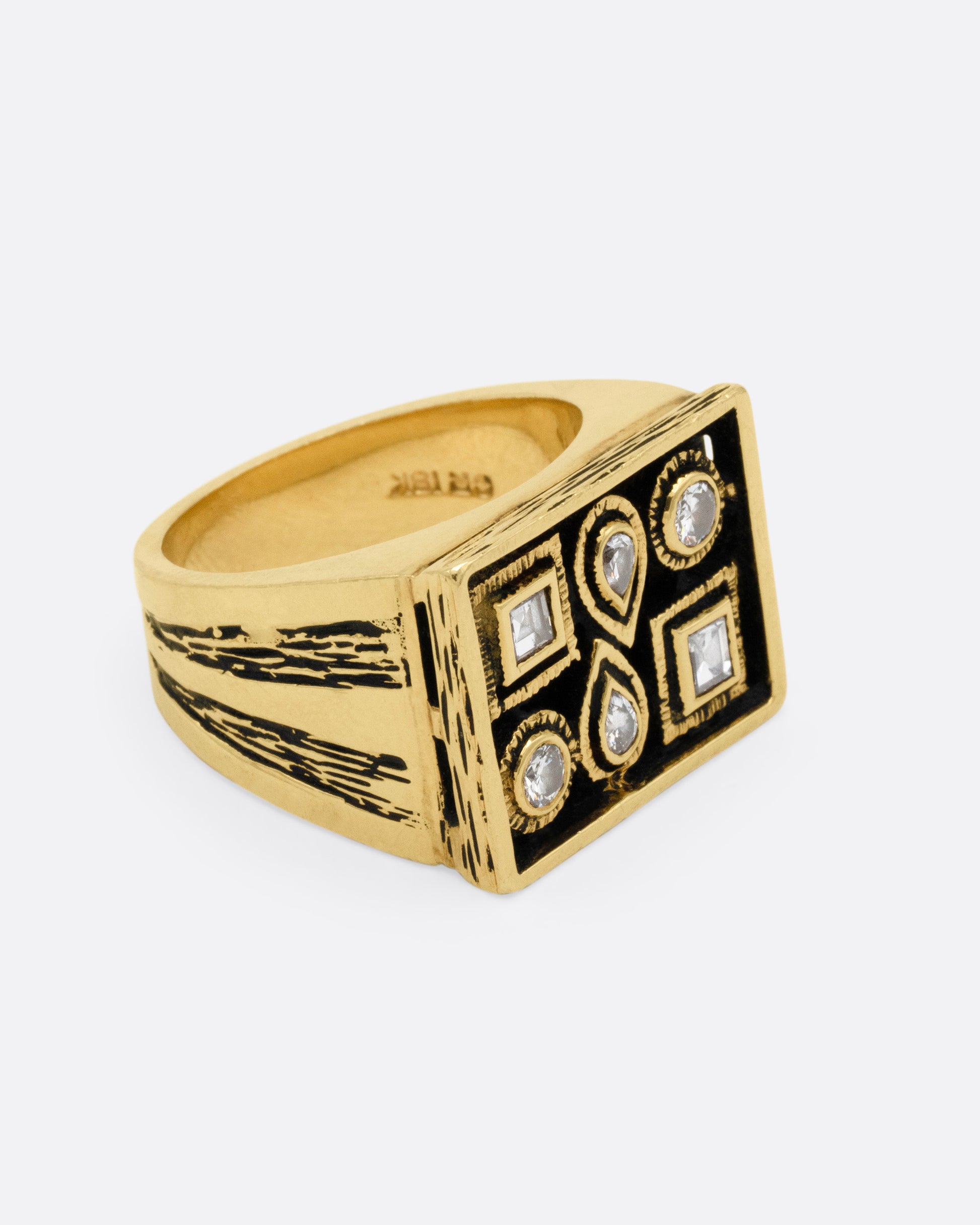 A rectangular yellow gold signet ring with mixed cut diamonds sand textured stone settings and shoulders, shown from the side.