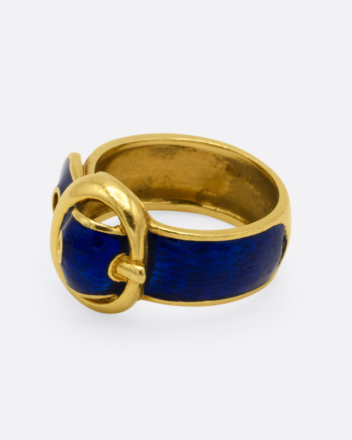 A yellow gold belt buckle ring with blue enamel, shown from the side.