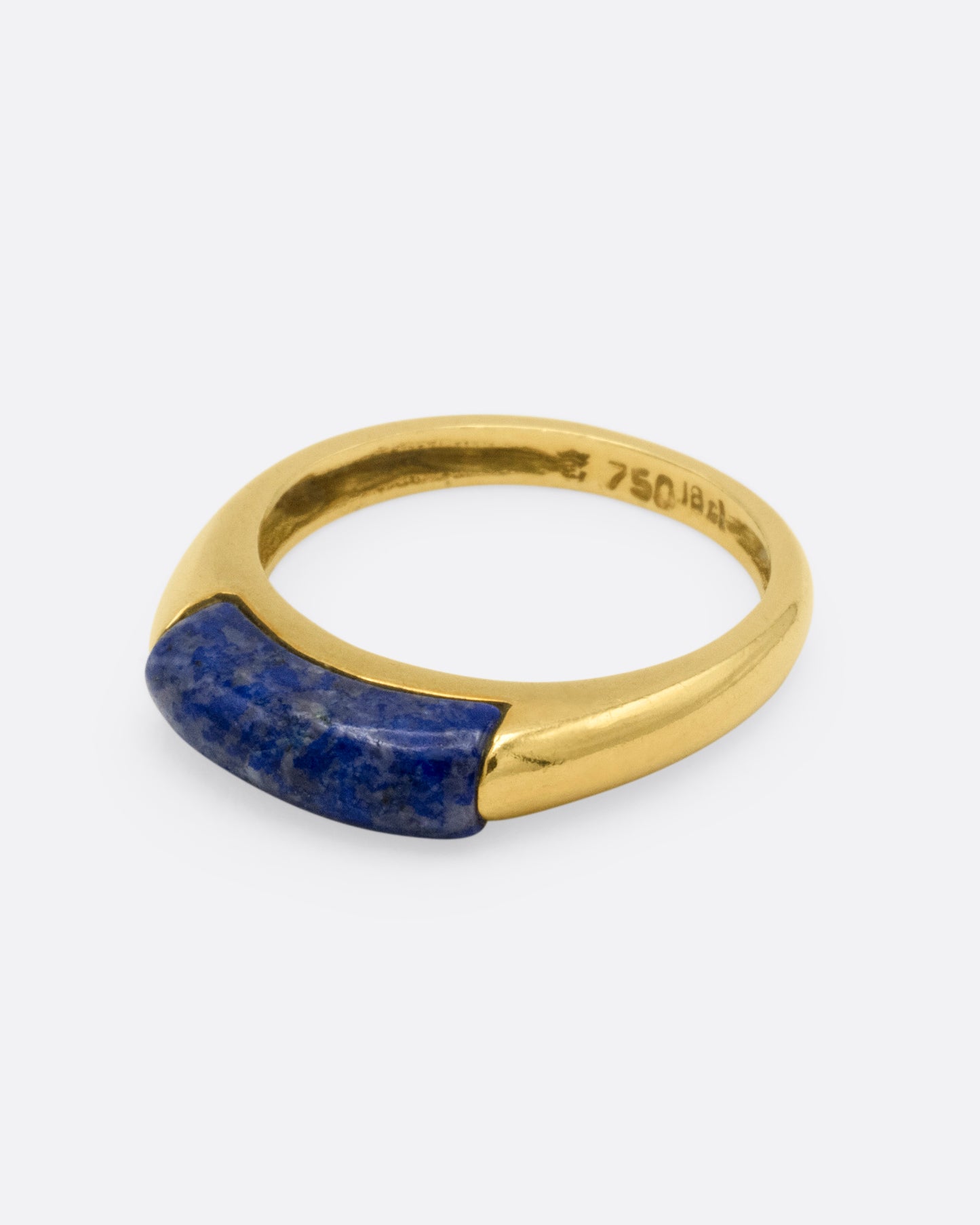 A yellow gold signet ring with a rounded silhouette and bar of lapis, shown from the side.