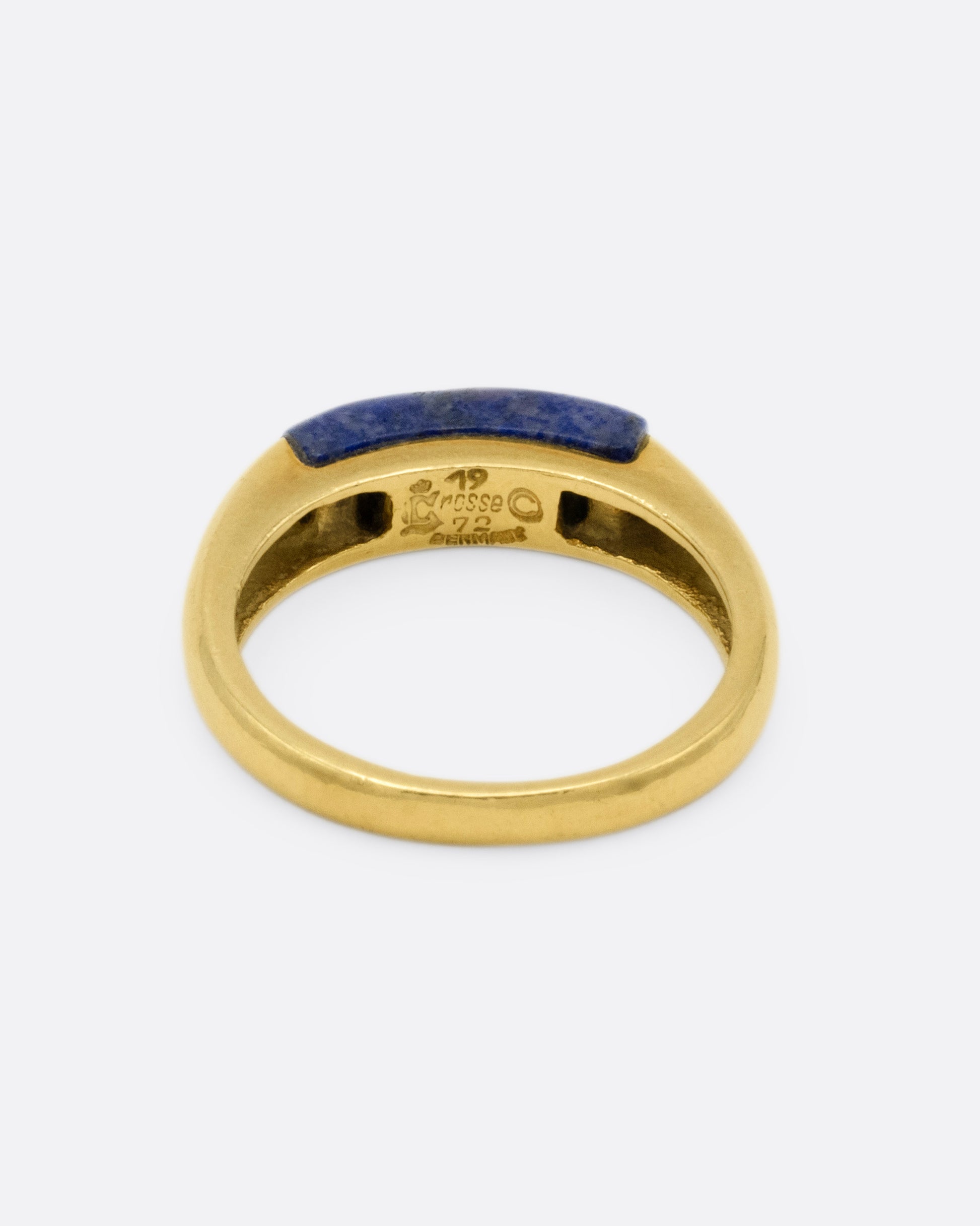 A yellow gold signet ring with a rounded silhouette and bar of lapis, shown from the back.