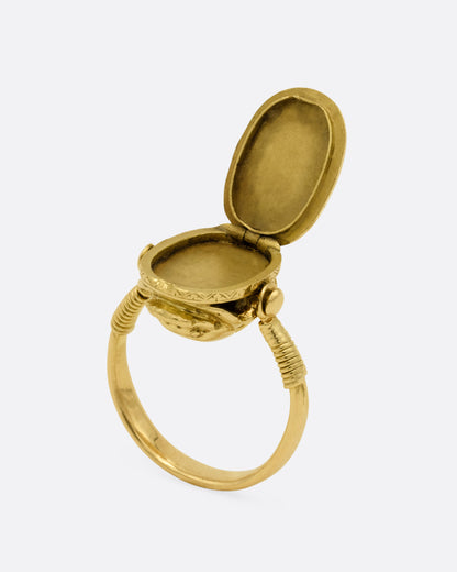 An Egyptian revival (c.1860) yellow gold scarab shaped locket ring, shown open from the side.