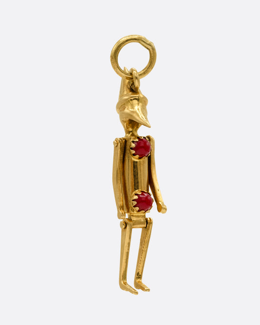  A yellow gold articulated Pierrot clown with two coral 'pom poms' atop his signature costume. Shown from the side.