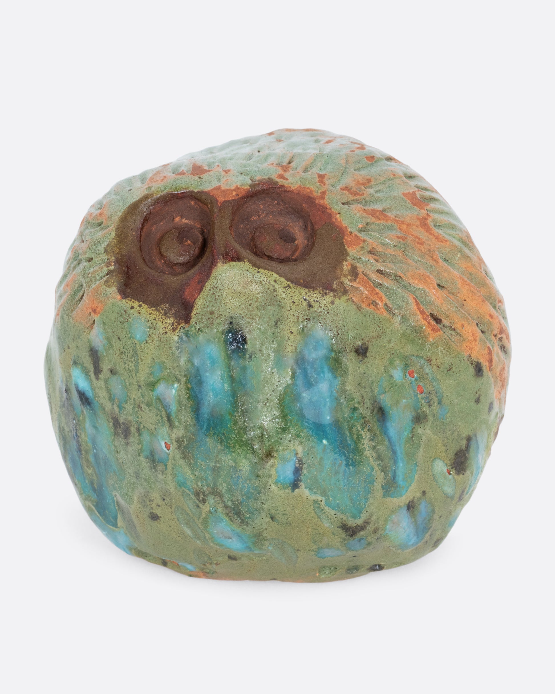 A  ceramic owl with a vibrant hand painted glaze. Shown from the front.