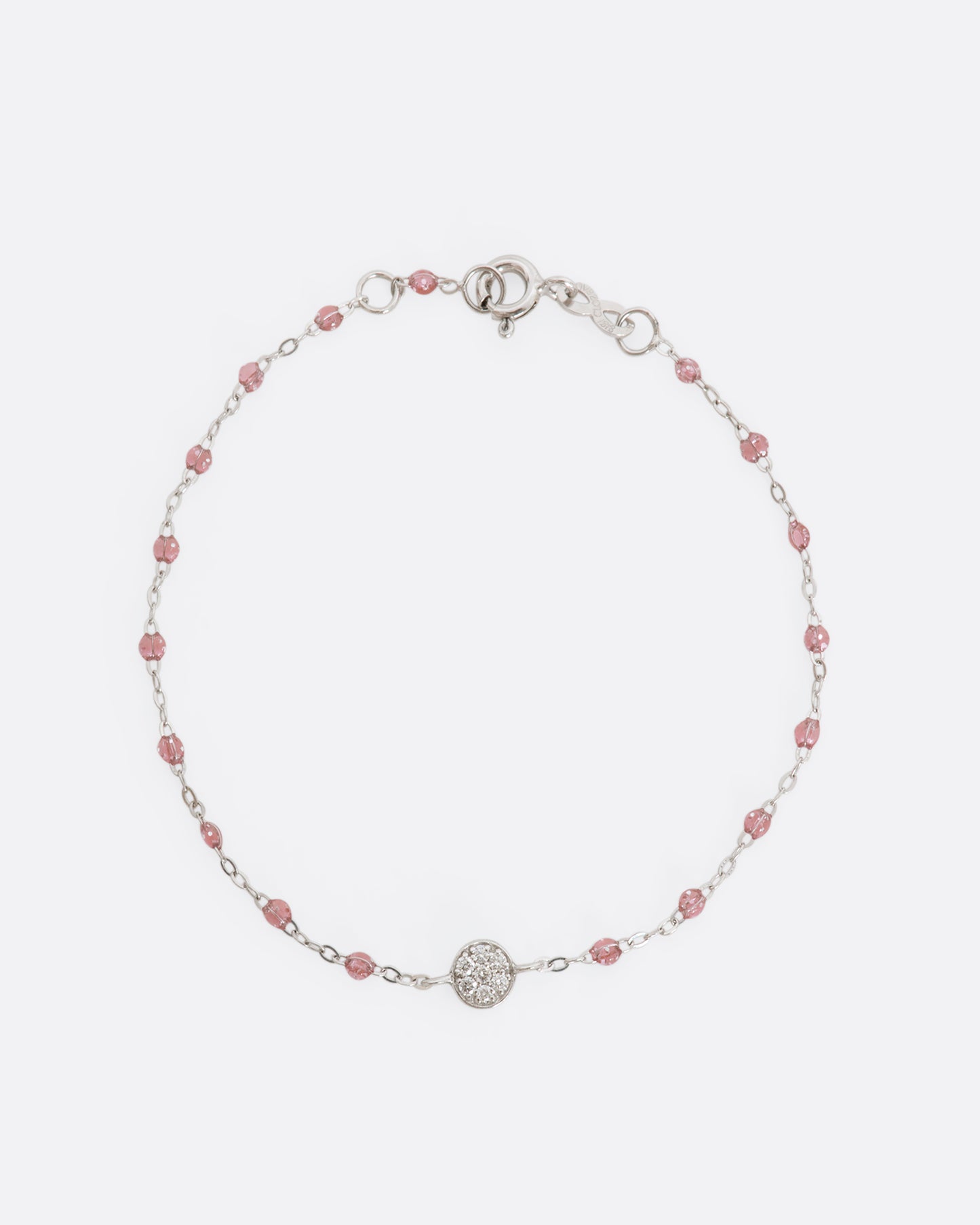 A white gold bracelet with rose pink glitter resin beads and a pave diamond disc and the center. View from above laying flat.