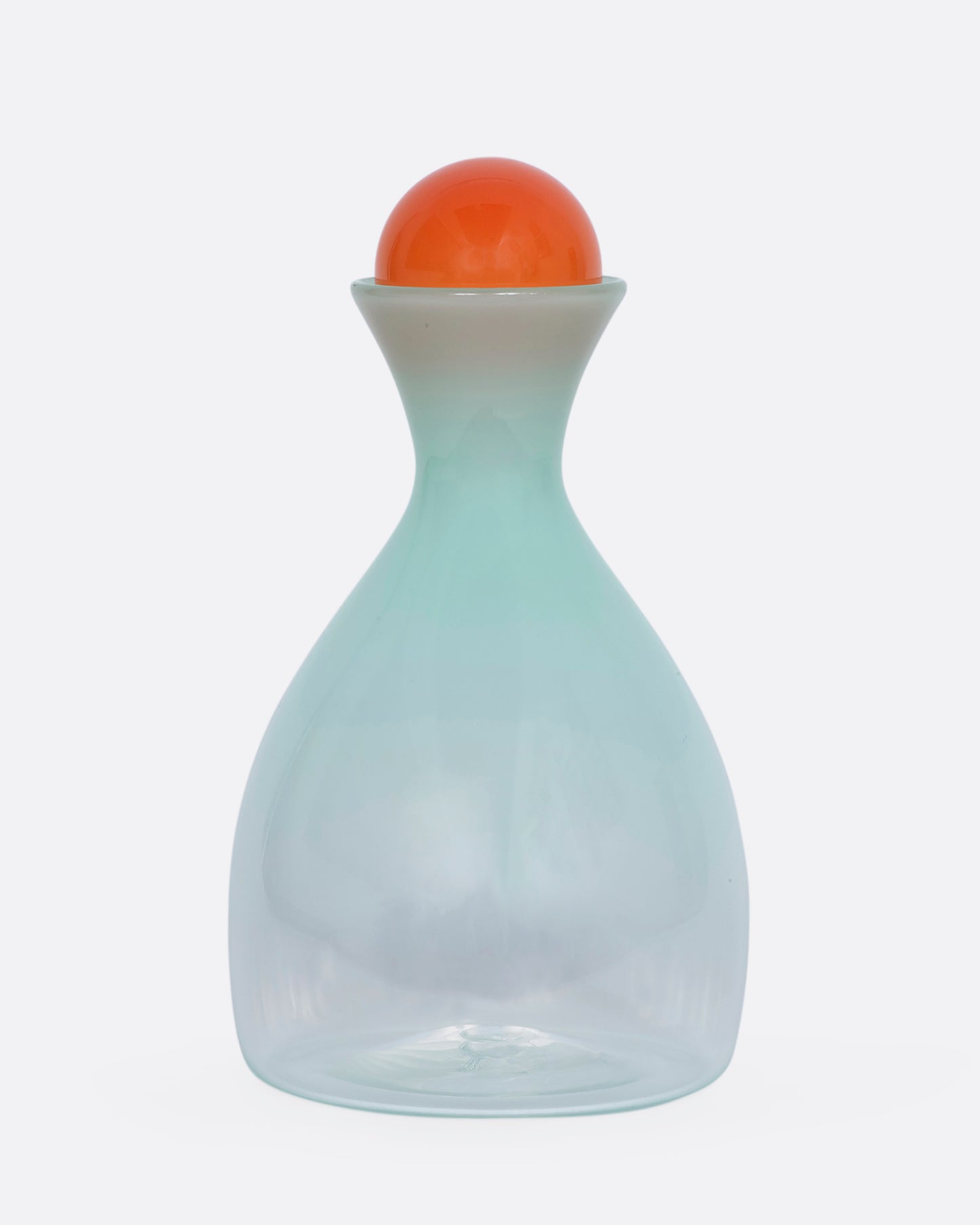 A mint green decanter with an orange sphere stopper. View from the front.