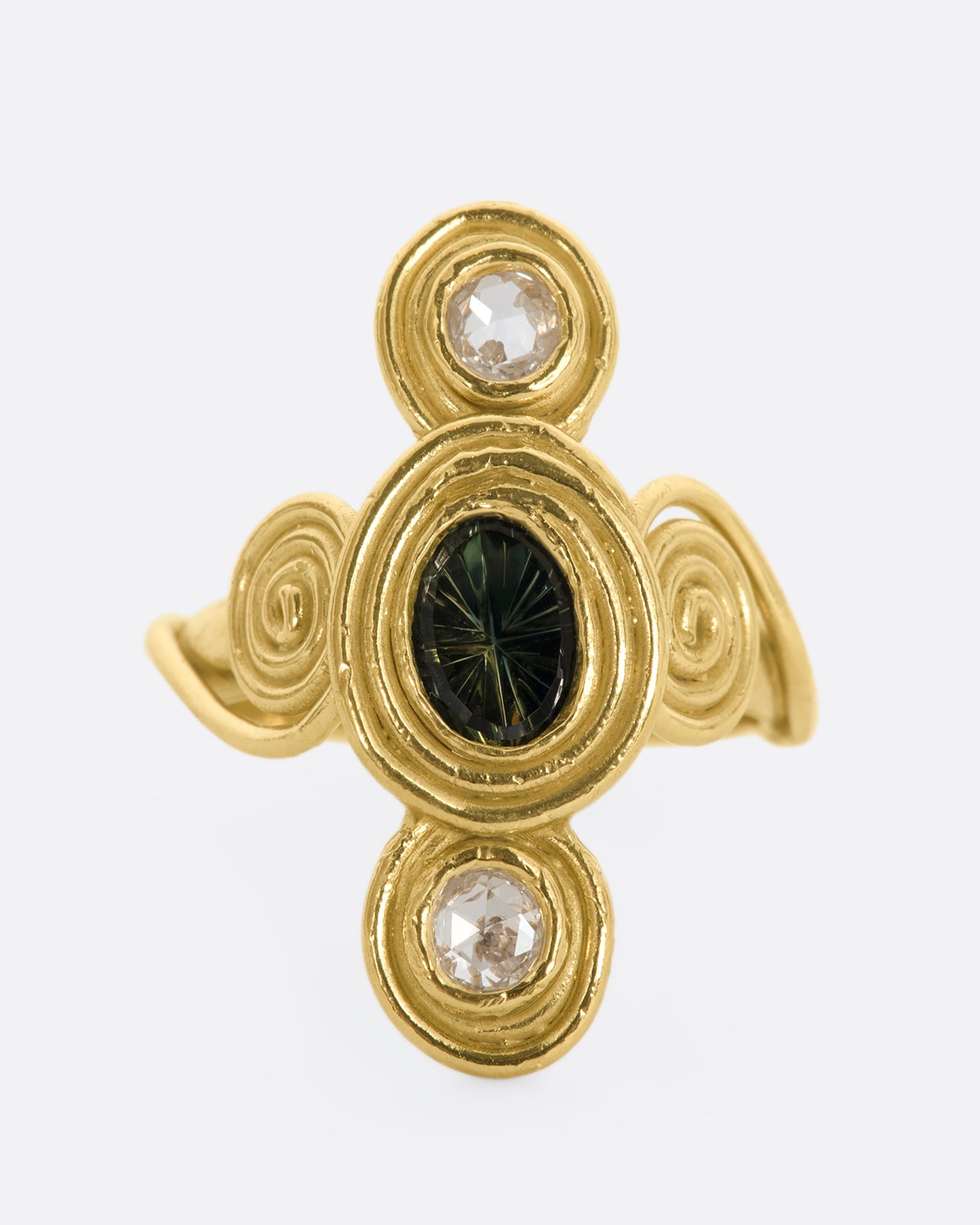 A yellow gold ring with circle and spiral motifs. At the center is a parti-color Australian sapphire with a rose cut diamond above and below. View from the front.