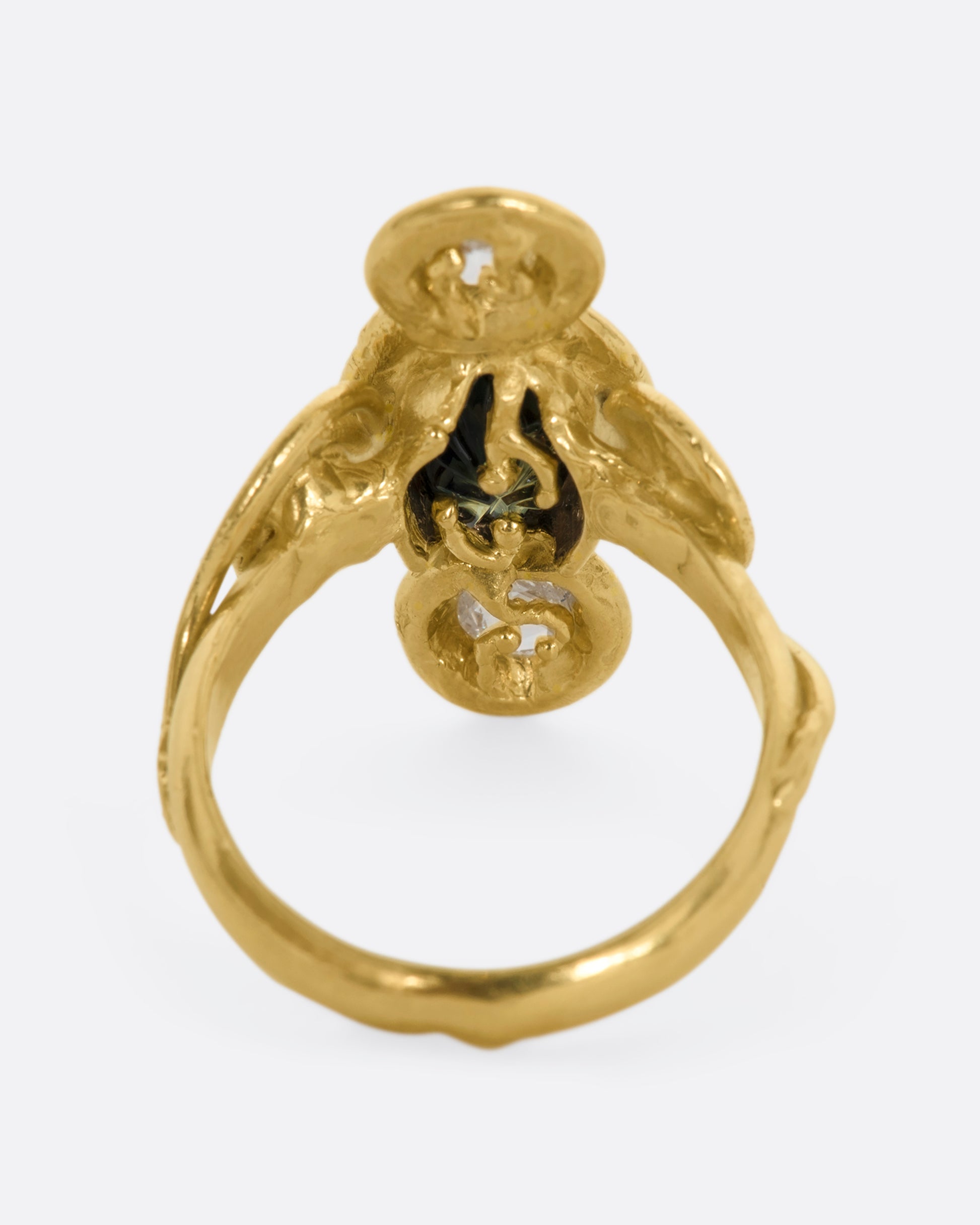 A yellow gold ring with circle and spiral motifs. At the center is a parti-color Australian sapphire with a rose cut diamond above and below. View from the back.