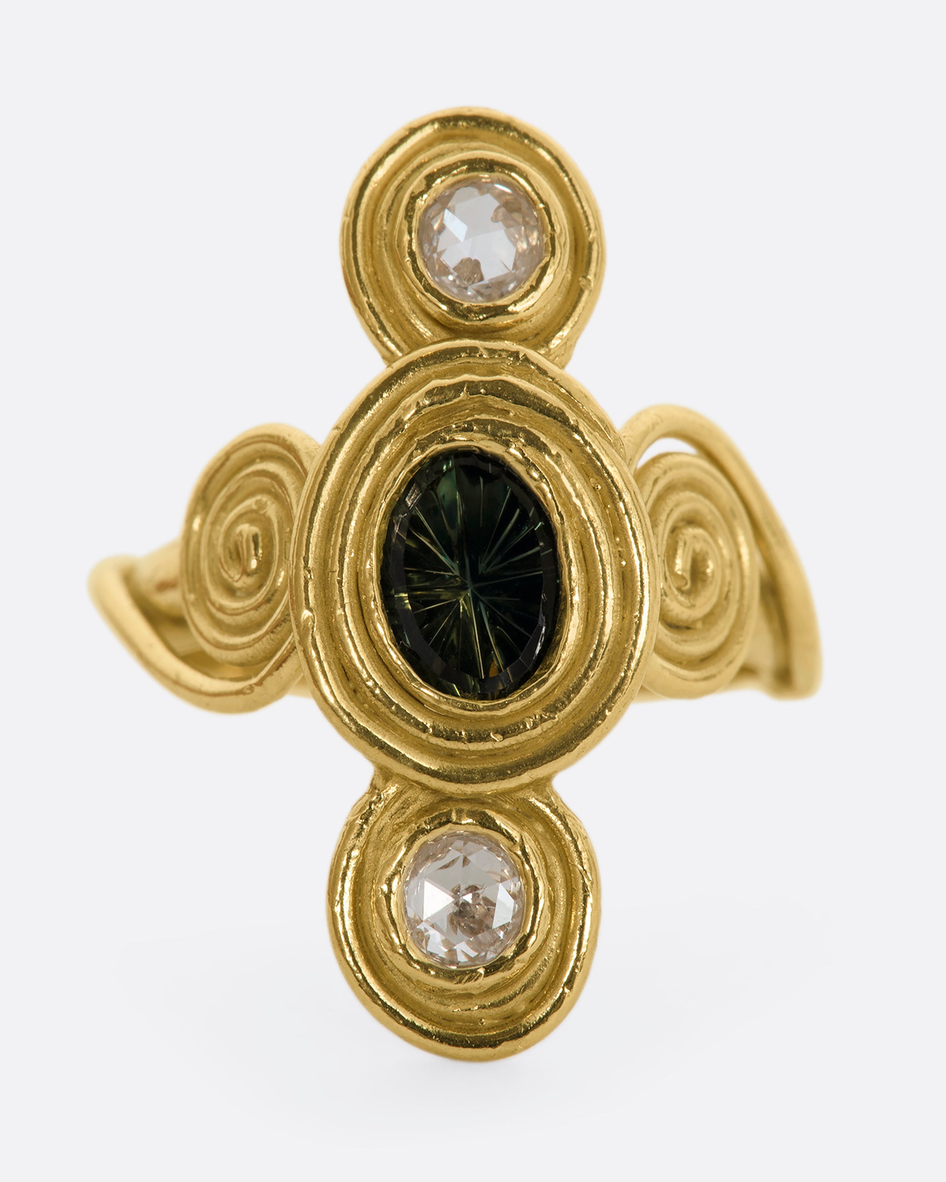 A yellow gold ring with circle and spiral motifs. At the center is a parti-color Australian sapphire with a rose cut diamond above and below. View close up of the stones.