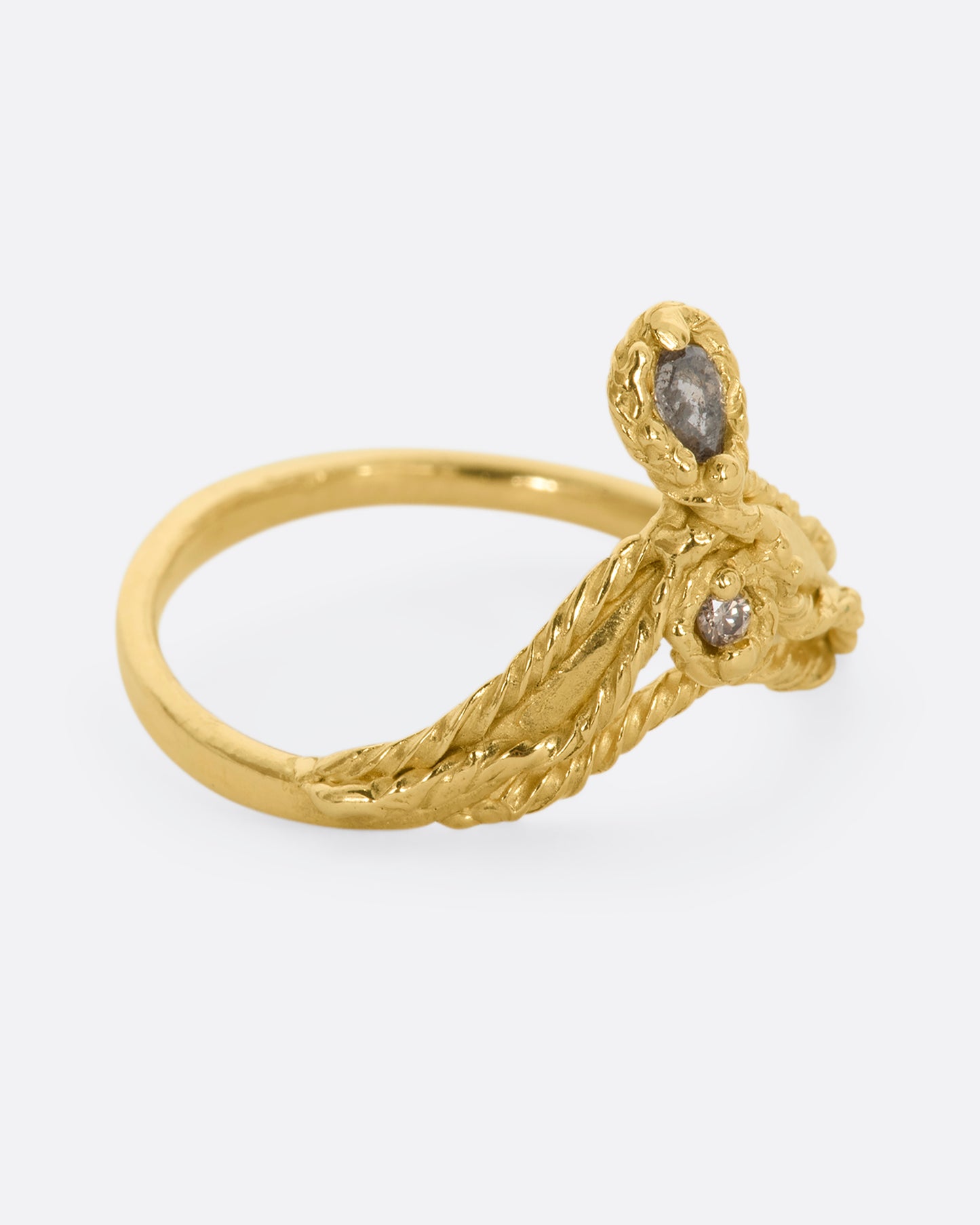 A yellow gold tiara shaped ring with twisted gold details, a rose cut salt and pepper tear drop diamond and a brilliant cut champagne diamond. View from the alternate side.